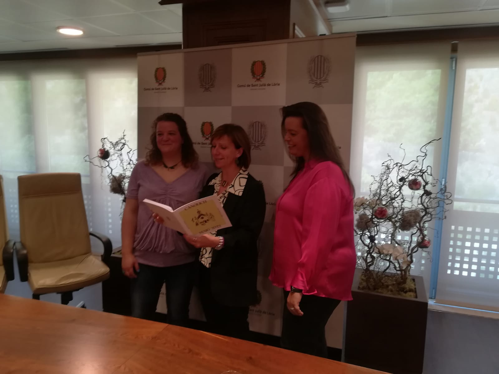 Anna Lluch, presidenta Coral Rocafort; Mireia Codina, cònsol menor; i Brigit Garcia, directora Coral Rocafort amb el llibret de Canòlich.