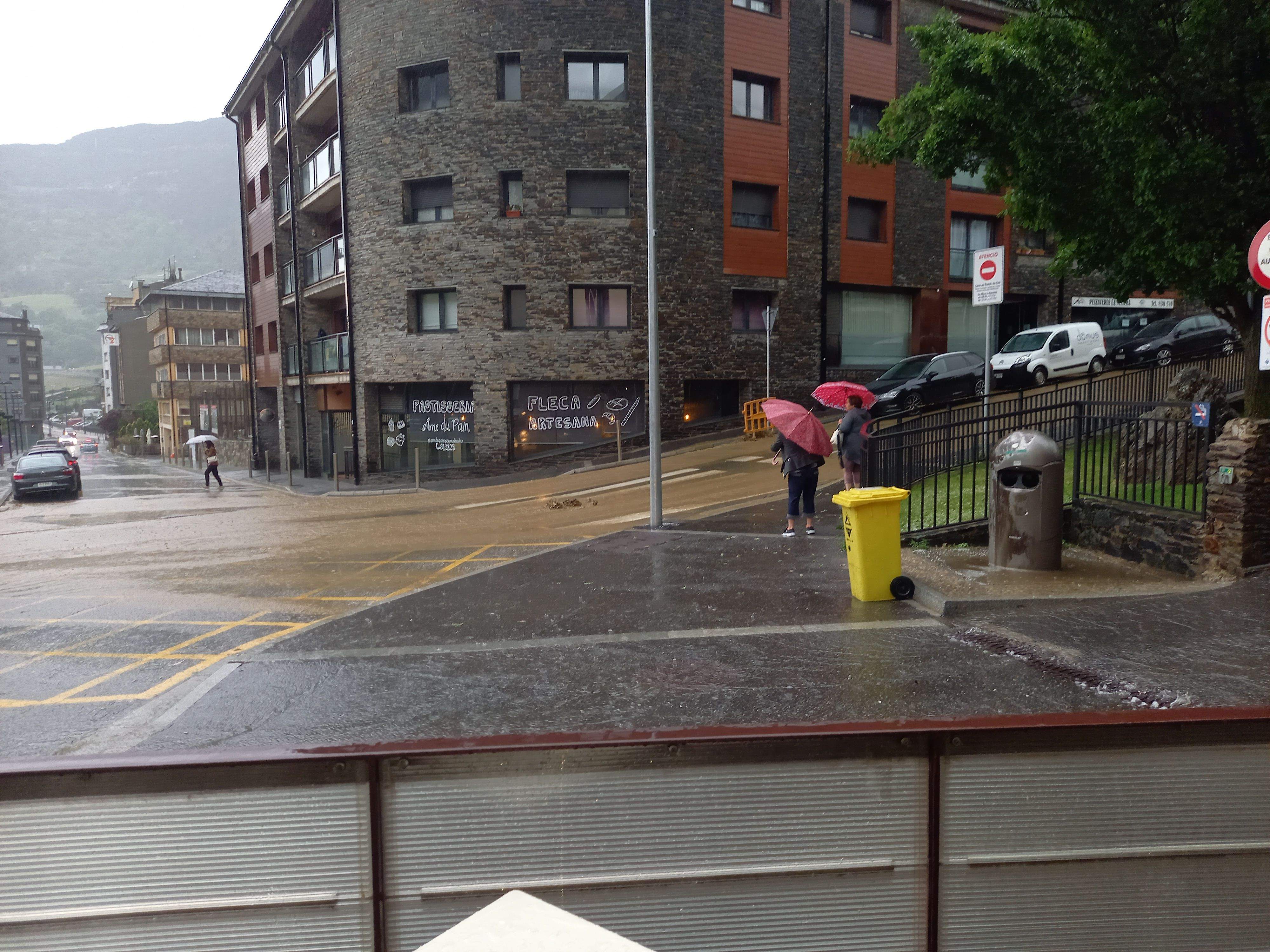 Dues dones intenten creuar el carrer Balcó del Solà a Encamp en un moment de gran acumulació d'aigua.