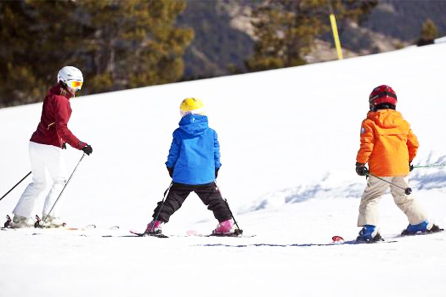 Nens practicant esquí a pistes.