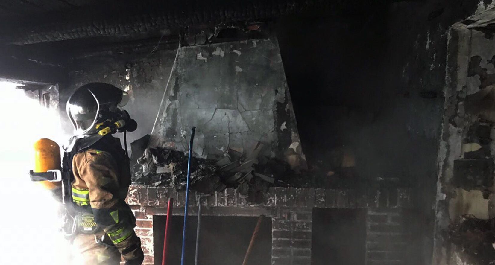 Un agent del cos d\'extinció d\'incendis observa els danys causats pel foc a la cuina americana de l\'àtic afectat.