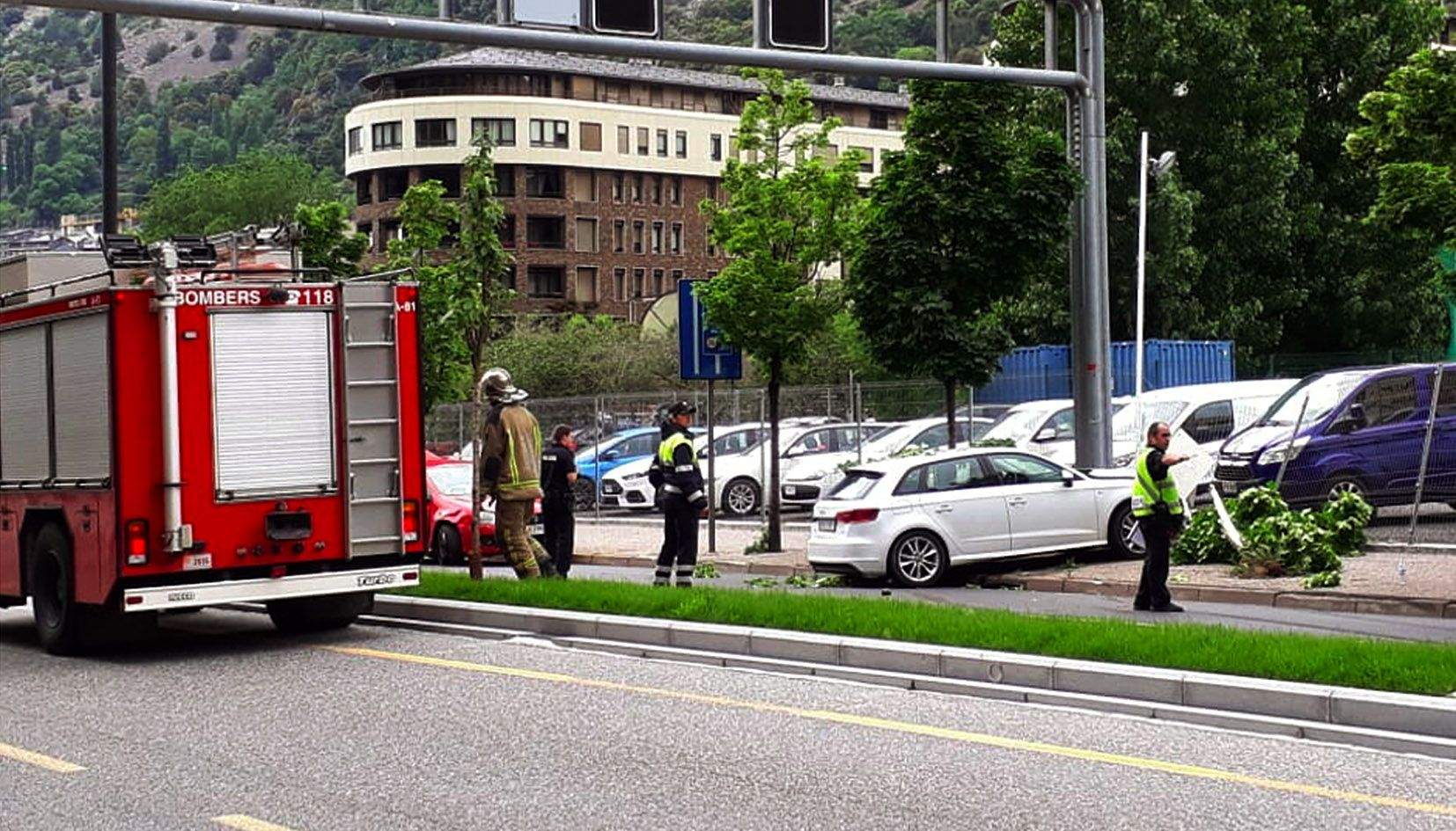 Agents de policia, de circulació i dels bombers treballant en el lloc dels fets amb els dos cotxes implicats encara en el mateix punt.
