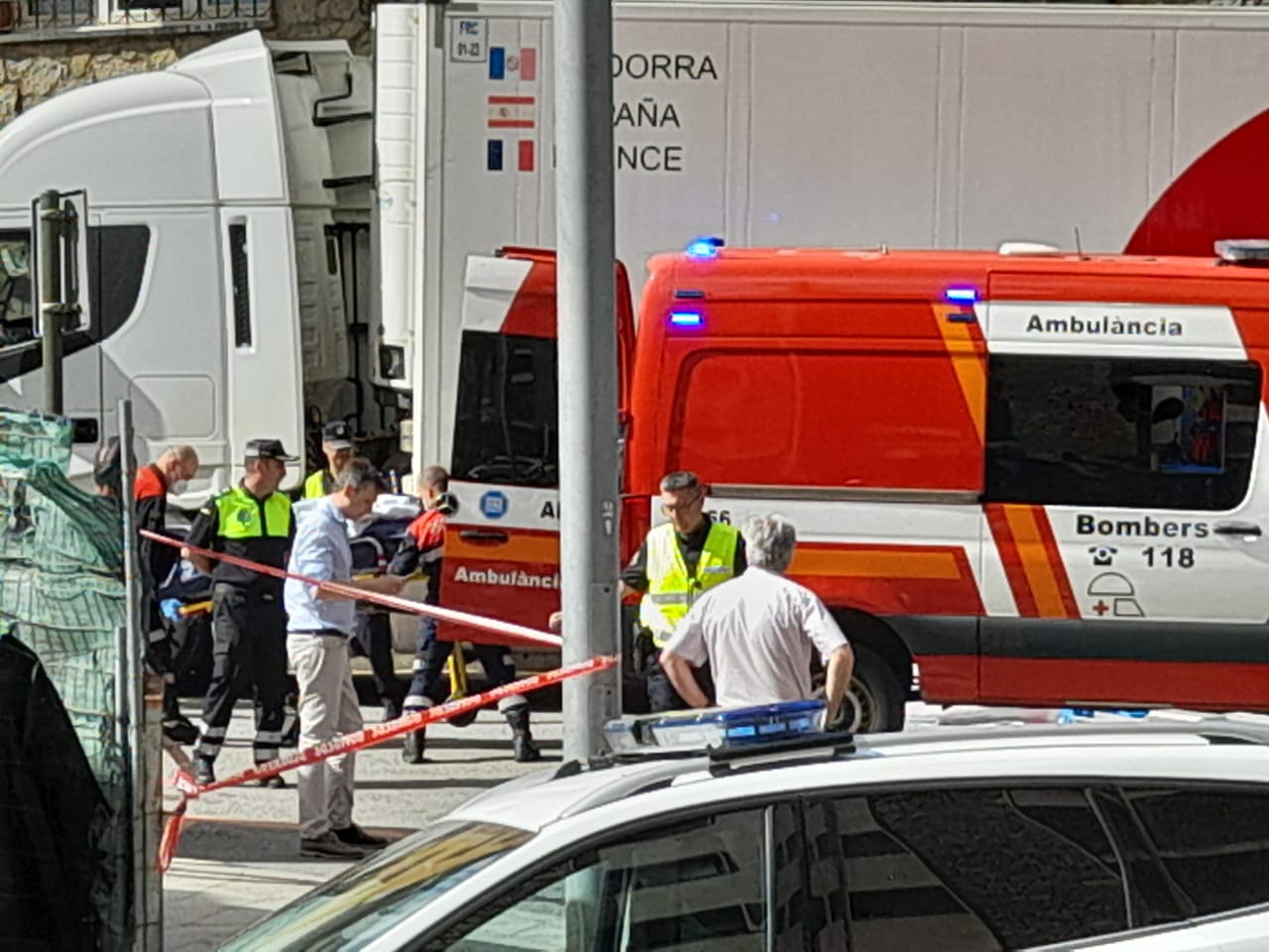 Efectius dels cossos de seguretat pugen el cos a l'ambulància un cop s'ha pogut recuperar de sota del camió.