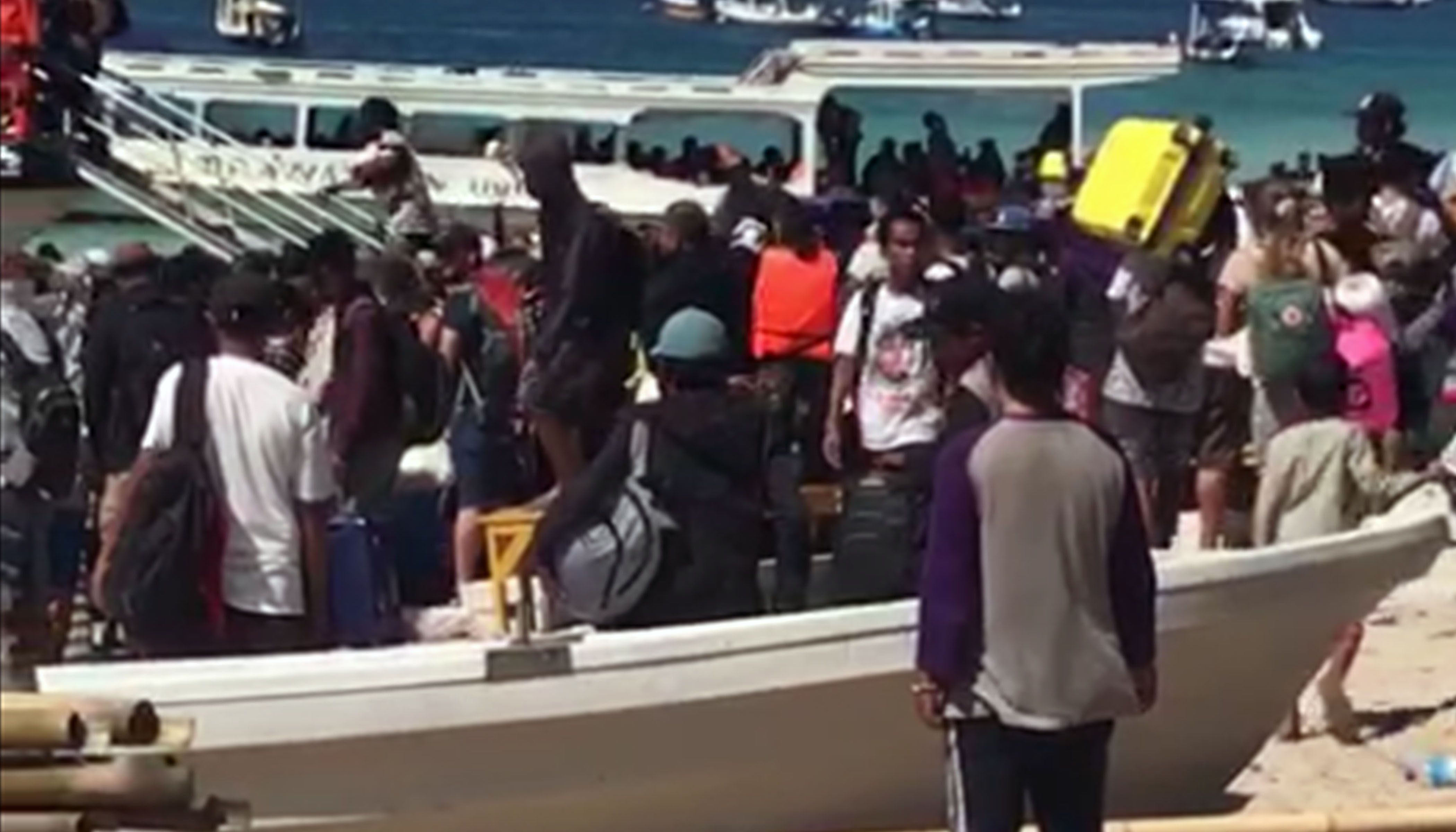 Habitants i turistes a l'illa de Gili Trawagan mirant d'embarcar per marxar de la zona davant el temor d'un tsunami.