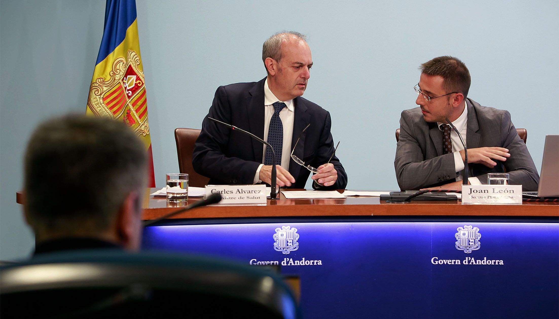 El ministre de Salut, Carles Álvarez, i el secretari d'Estat, Joan Antoni León, conversen en un moment de la presentació del projecte de llei observats pel titular d'Economia i Innovació, Gilbert Saboya.