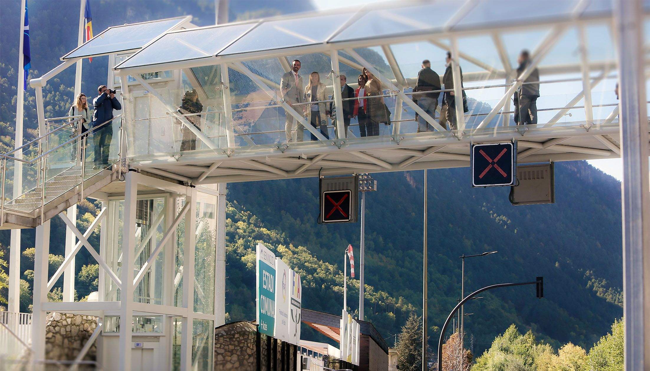 Autoritats observant la via des del pas elevat totalment cobert durant l'acte inaugural.