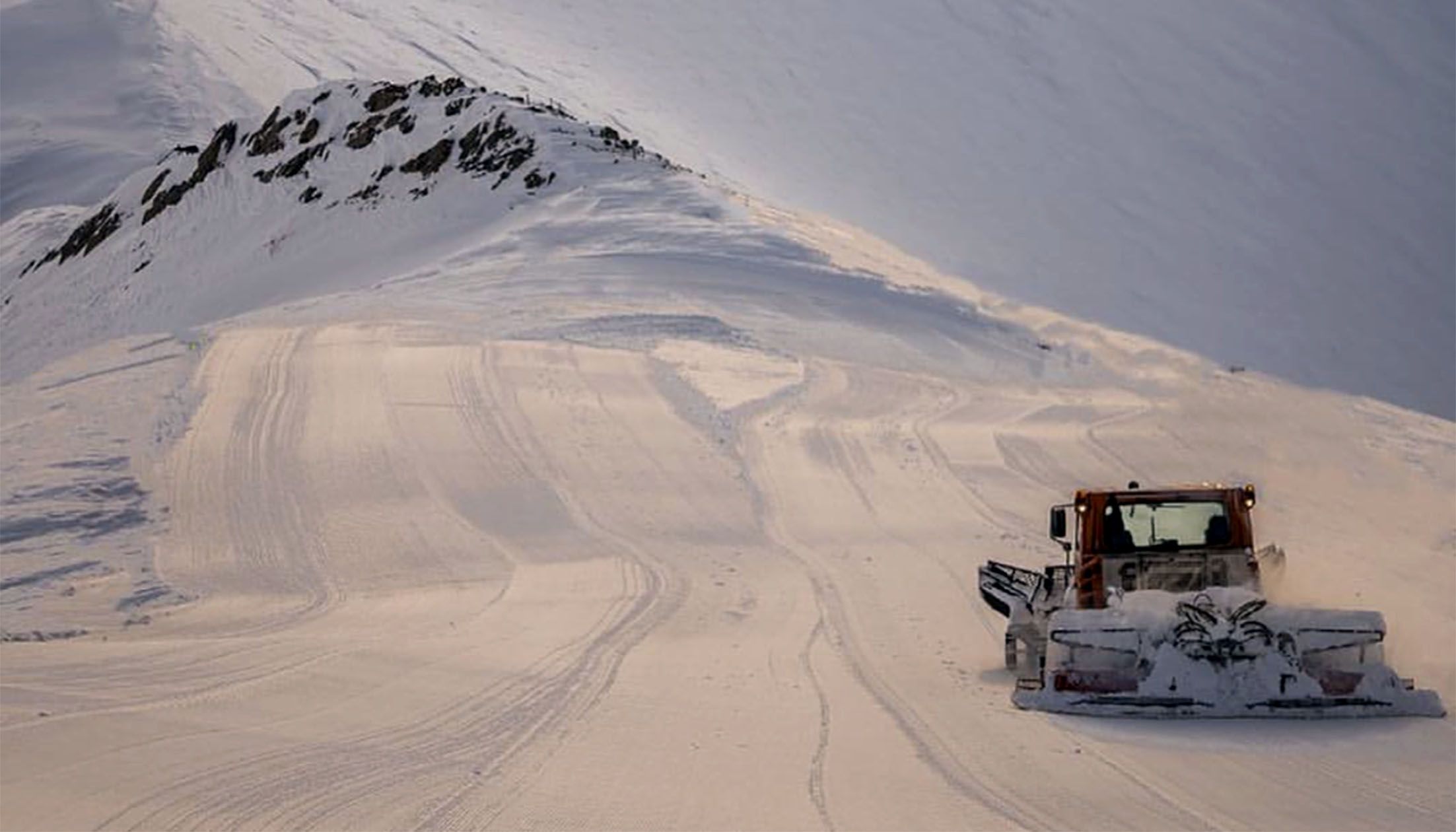 Un màquina treballant en una pista per consolidar la base de neu.