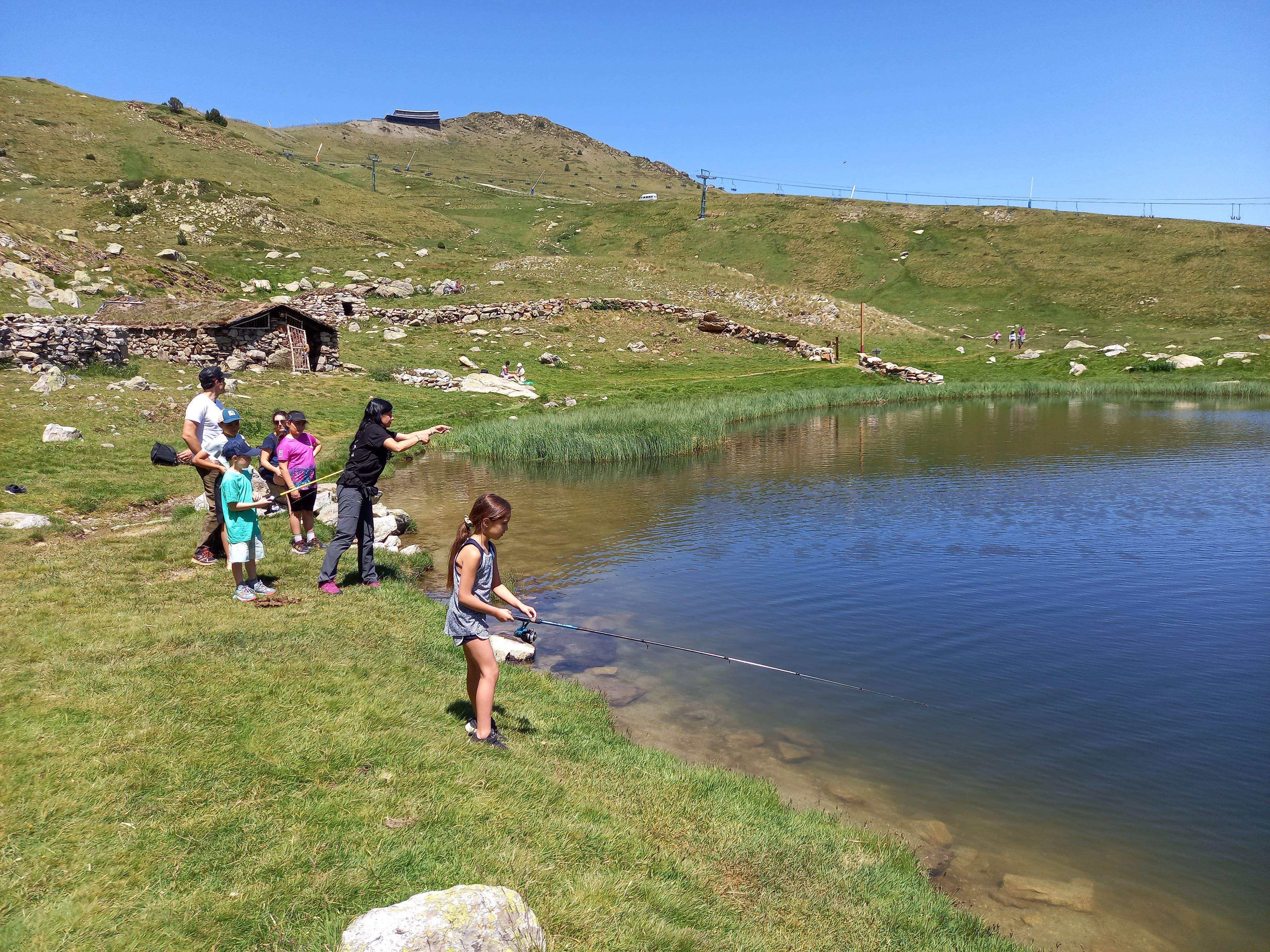 Un grup de nens practiquen pesca sense mort a l'estany del Cubill.