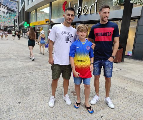 Els dos jugadors amb un jove aficionat que buscava una samarreta de l'FC Andorra.