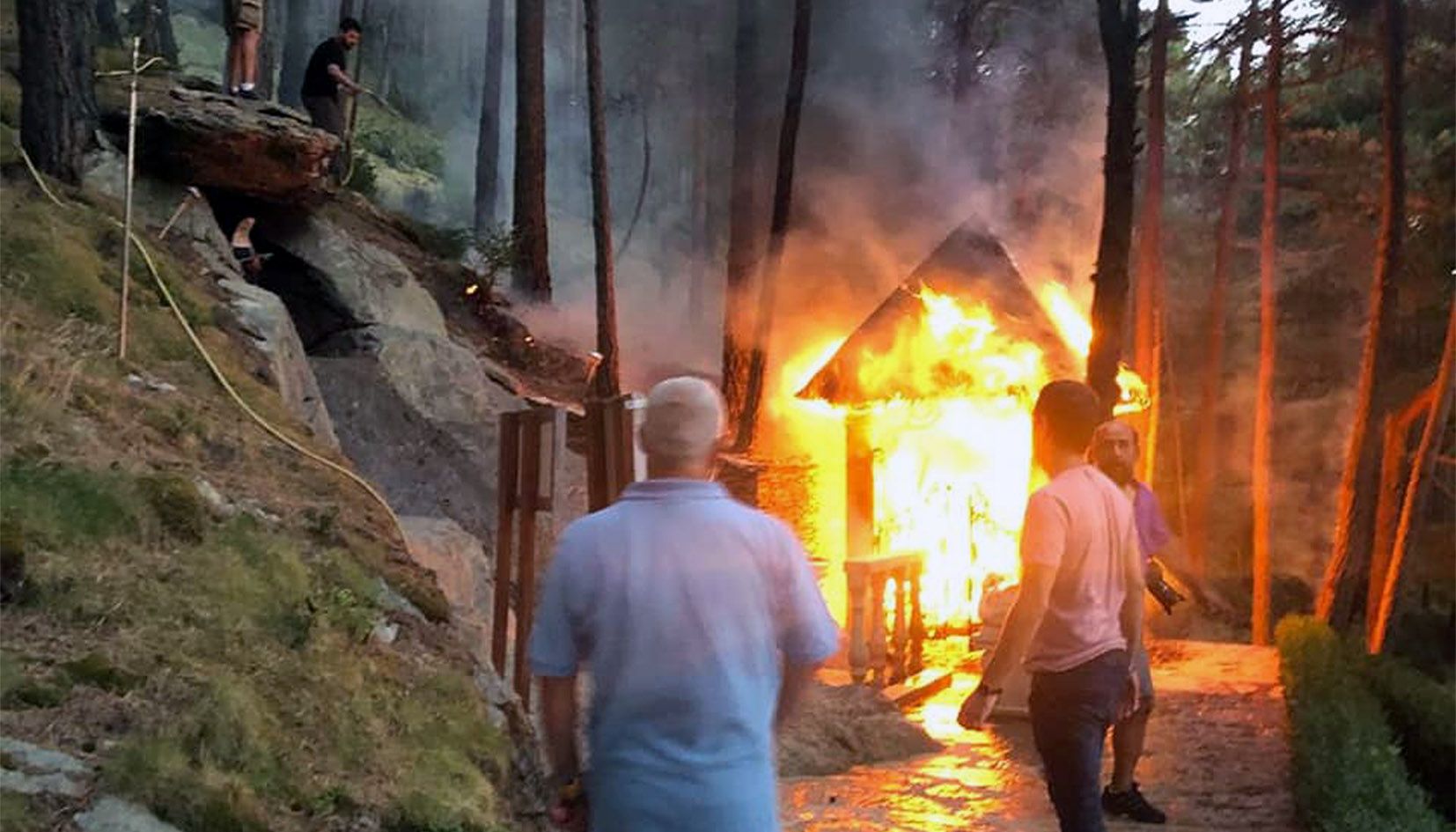 Veïns de Juberri miren d'apagar el foc ahir al vespre a la capella de santa Rita.