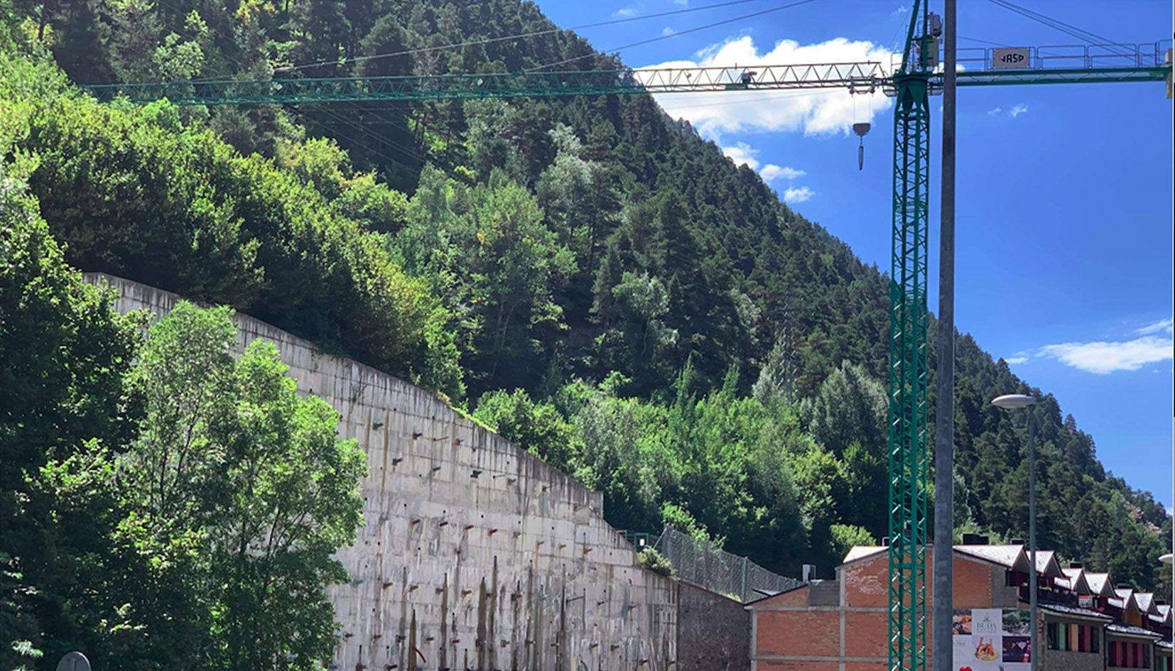 La grua, de grans dimensions, està muntada a tocar la carretera general i una excavació la construcció de la qual mai no s'ha bastit.