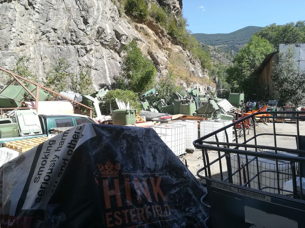 Material de la deixalleria comunal de Sant Julià de Lòria en una parcel·la a l'aire lliure.
