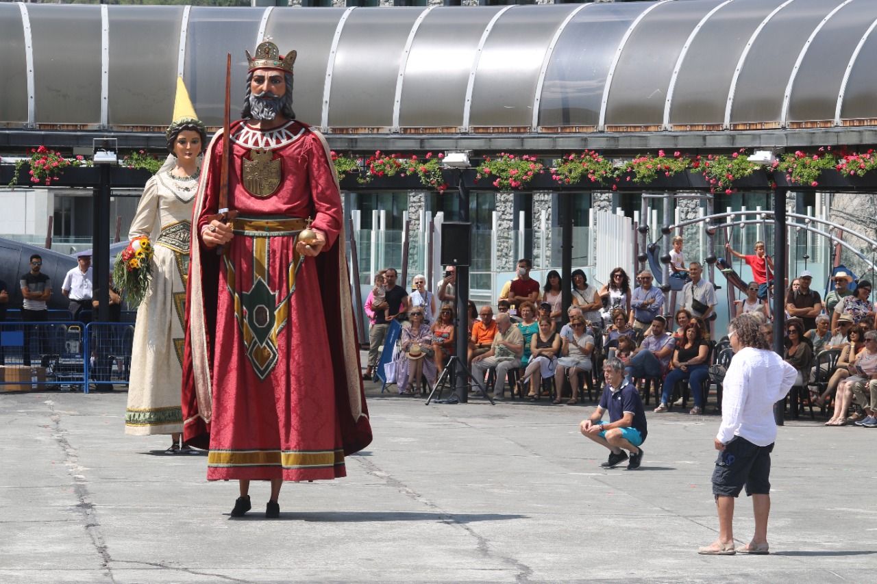 La mare i el germà de l'Arnau fan ballar els gegants, mentre el pare (a la dreta i amb camisa blanca) els observa.