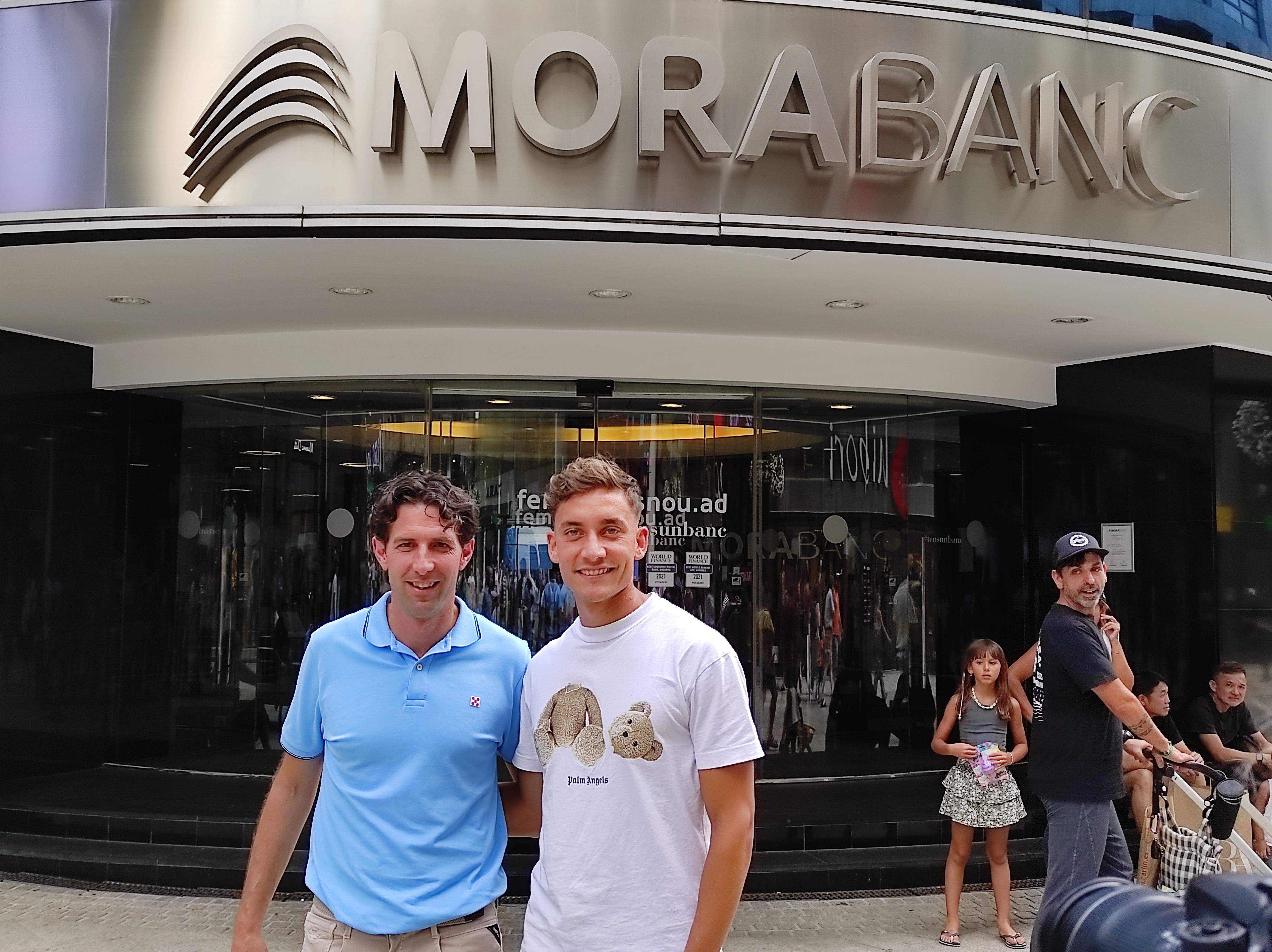 Jaume Nogués amb Alex Petxarroman observats per turistes davant la seu de MoraBanc.