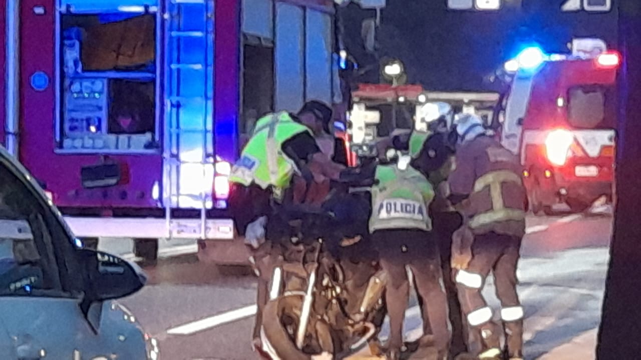 Agents de la policia i dels bombers amb la moto implicada.