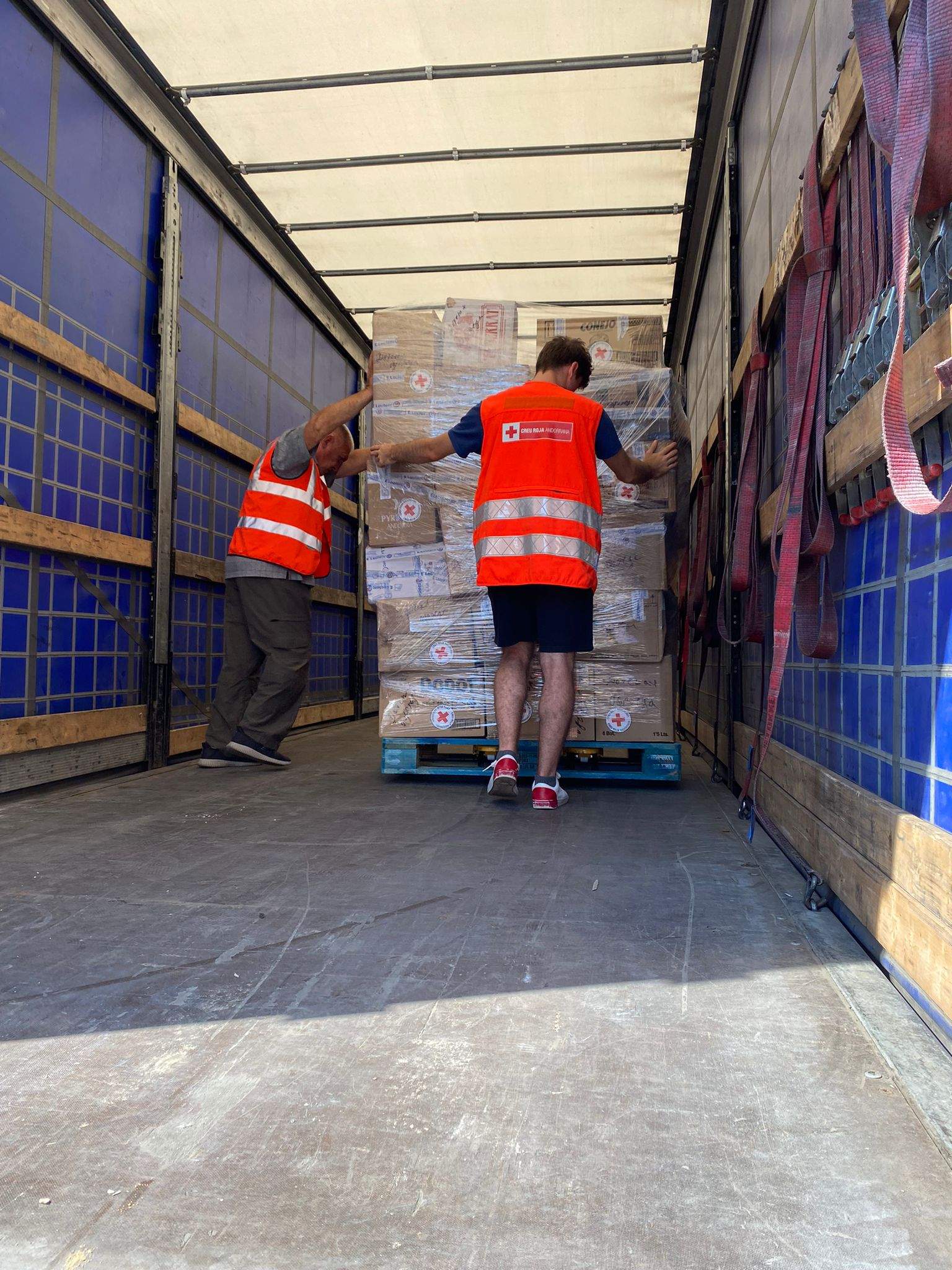 Voluntaris carregant material a un comboi de Creu Roja.