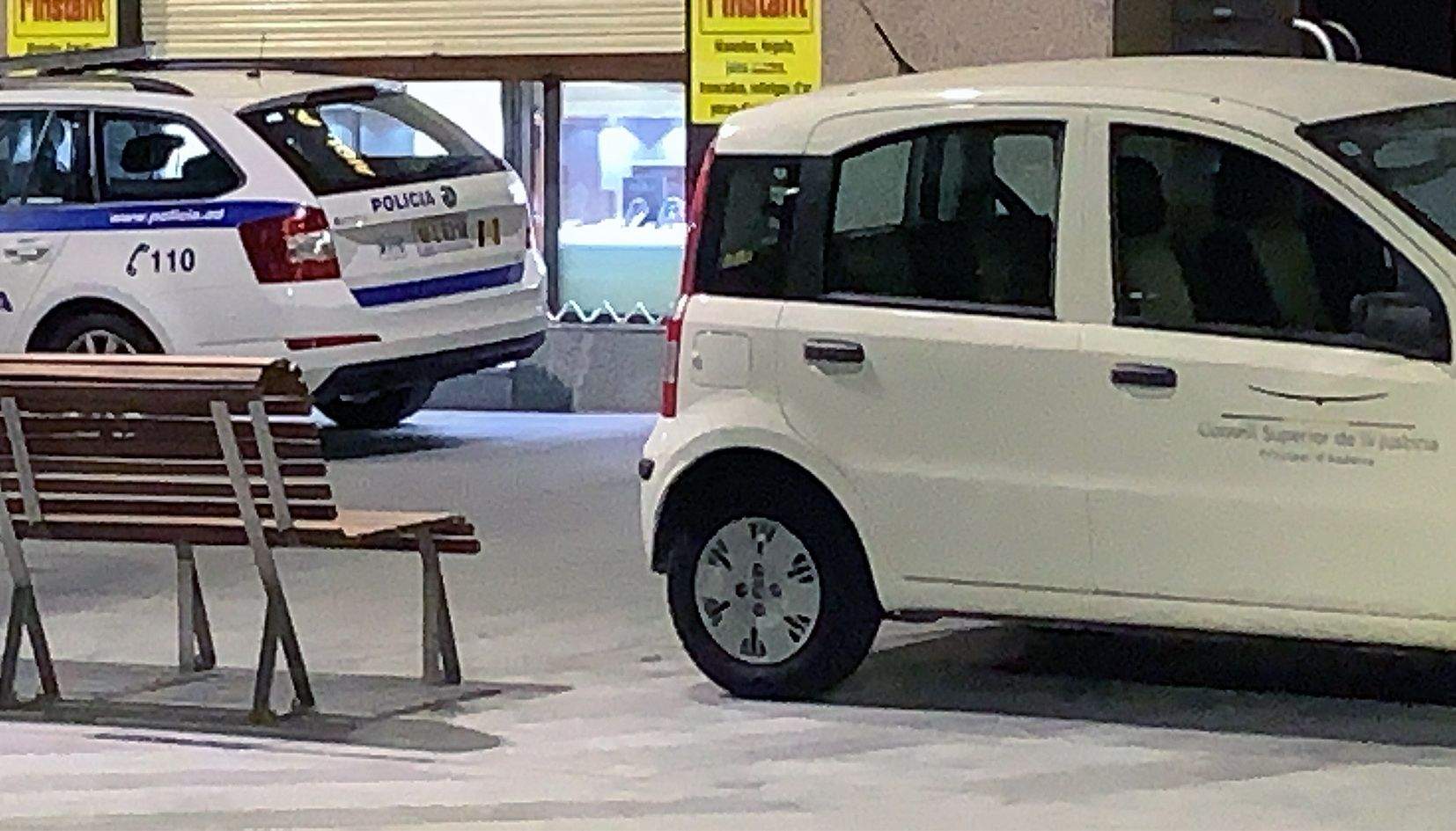 Un cotxe policial i el vehicle del Consell Superior de la Justícia amb què es van traslladar els fiscals a l'establiment on es va produir la detenció.