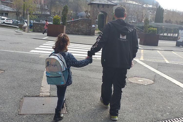 Un pare i la seva filla marxen cap a casa després de recollir-la de l'escola.