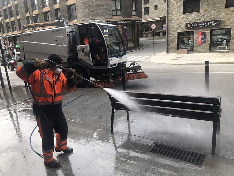 Un operari neteja un banc a la Massana.