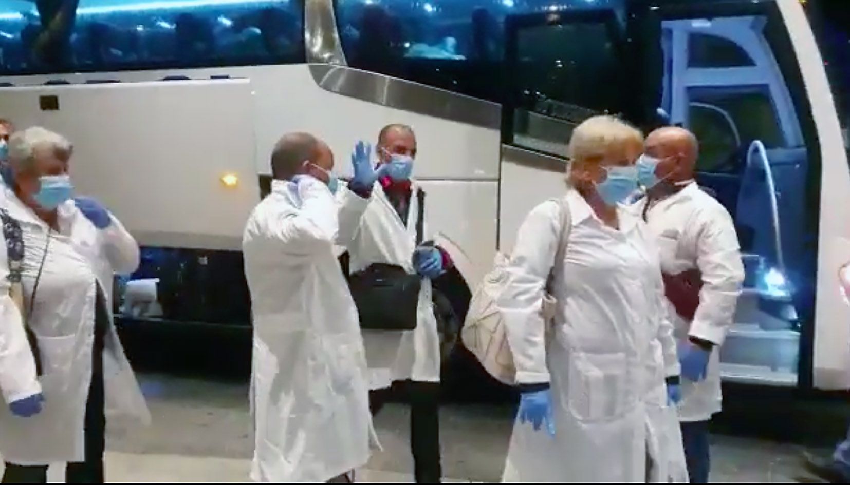 Alguns dels sanitaris cubans saluden al peu de l'hotel on han estat allotjats.