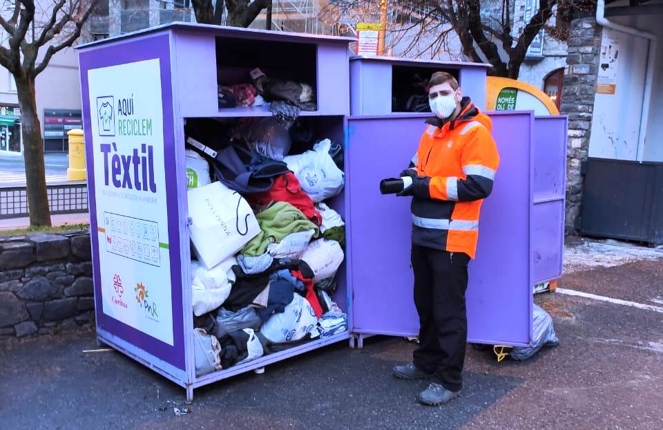 Un operari del comú d'Encamp buida un dels contenidors de roba.