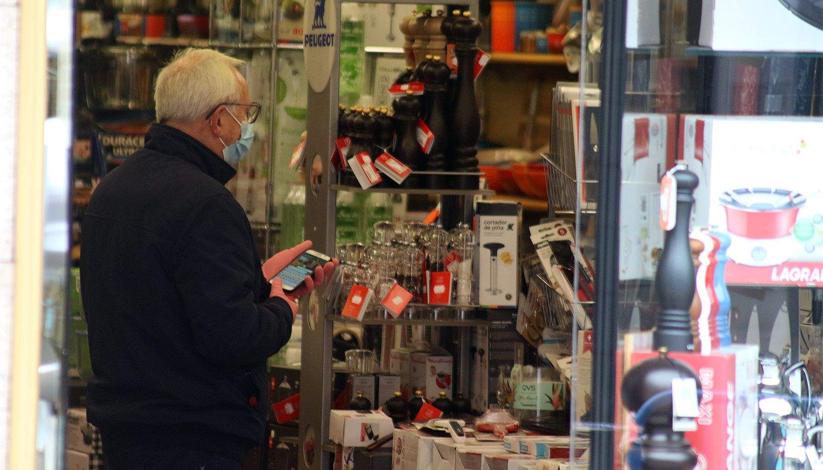Un home observa l'aparador duna botiga d'electrònica.
