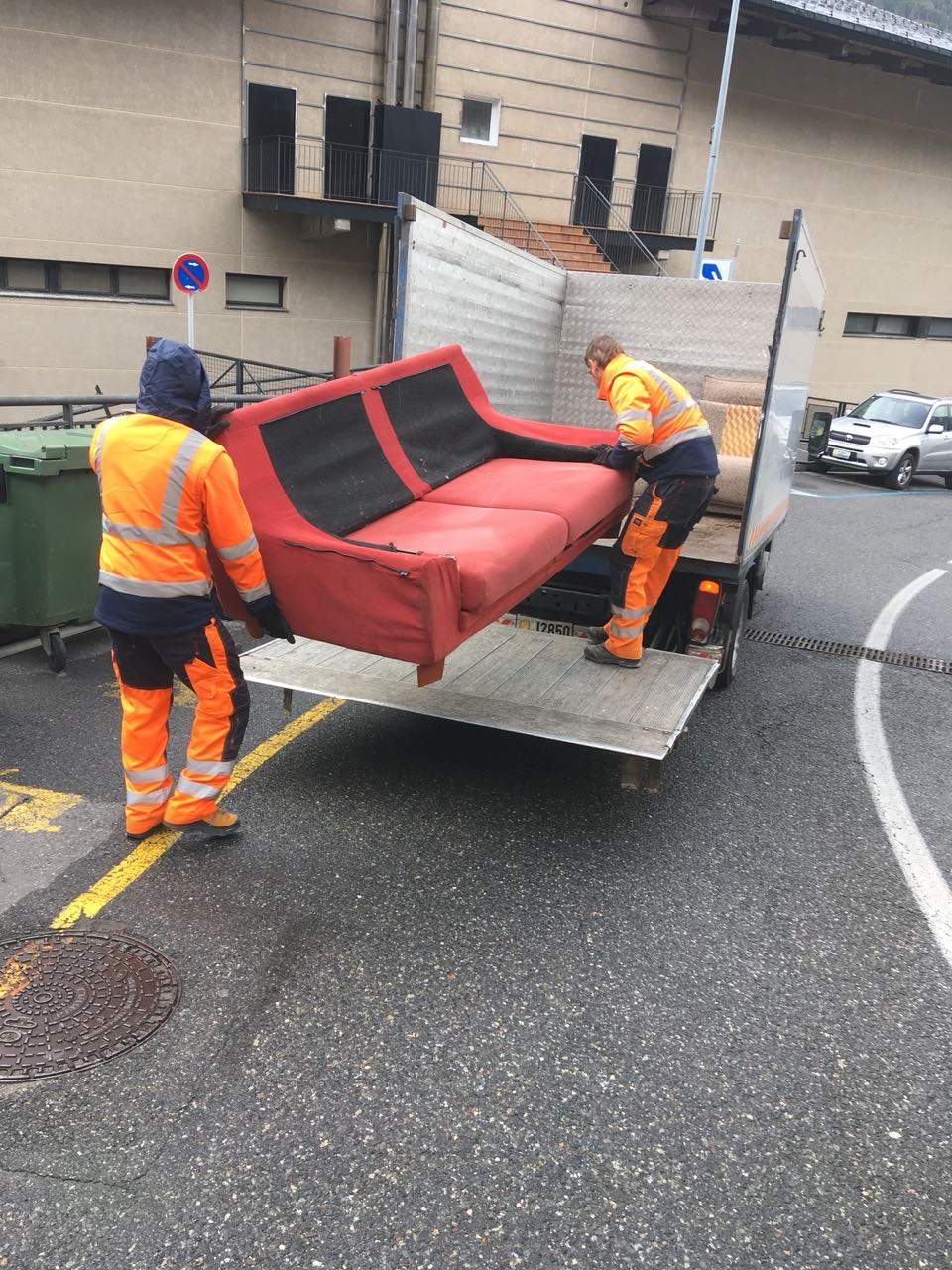 Operaris d'Encamp recullen un moble al carrer.