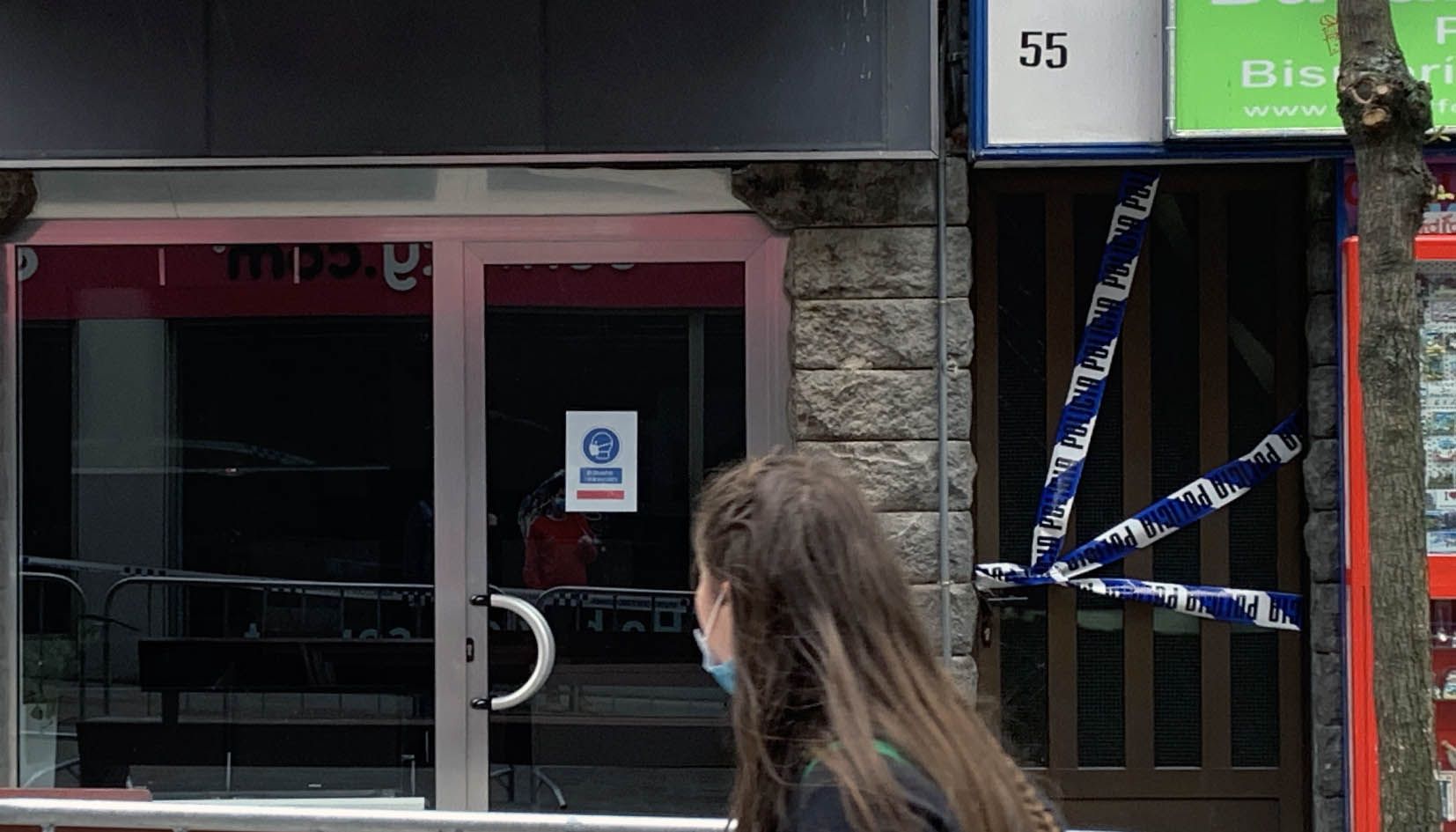 Una noia passa per davant de l'edifici sinistrat, l'entrada del qual està precintada per la policia. Una noia passa per davant de l'edifici sinistrat, l'entrada del qual està precintada per la policia.