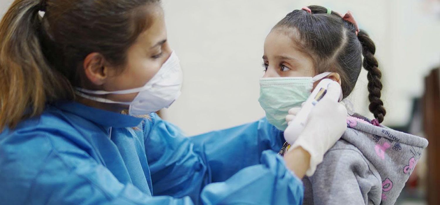 Una sanitària amb mascareta FFP2 atén una menor.