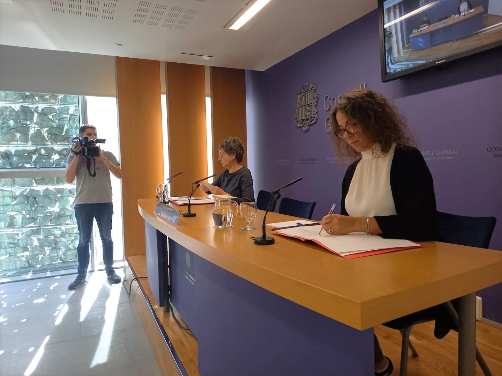 Un càmera grava les conselleres del PS Susanna Vela i Judith Salazar abans de la roda de premsa. Un càmera grava les conselleres del PS Susanna Vela i Judith Salazar abans de la roda de premsa.