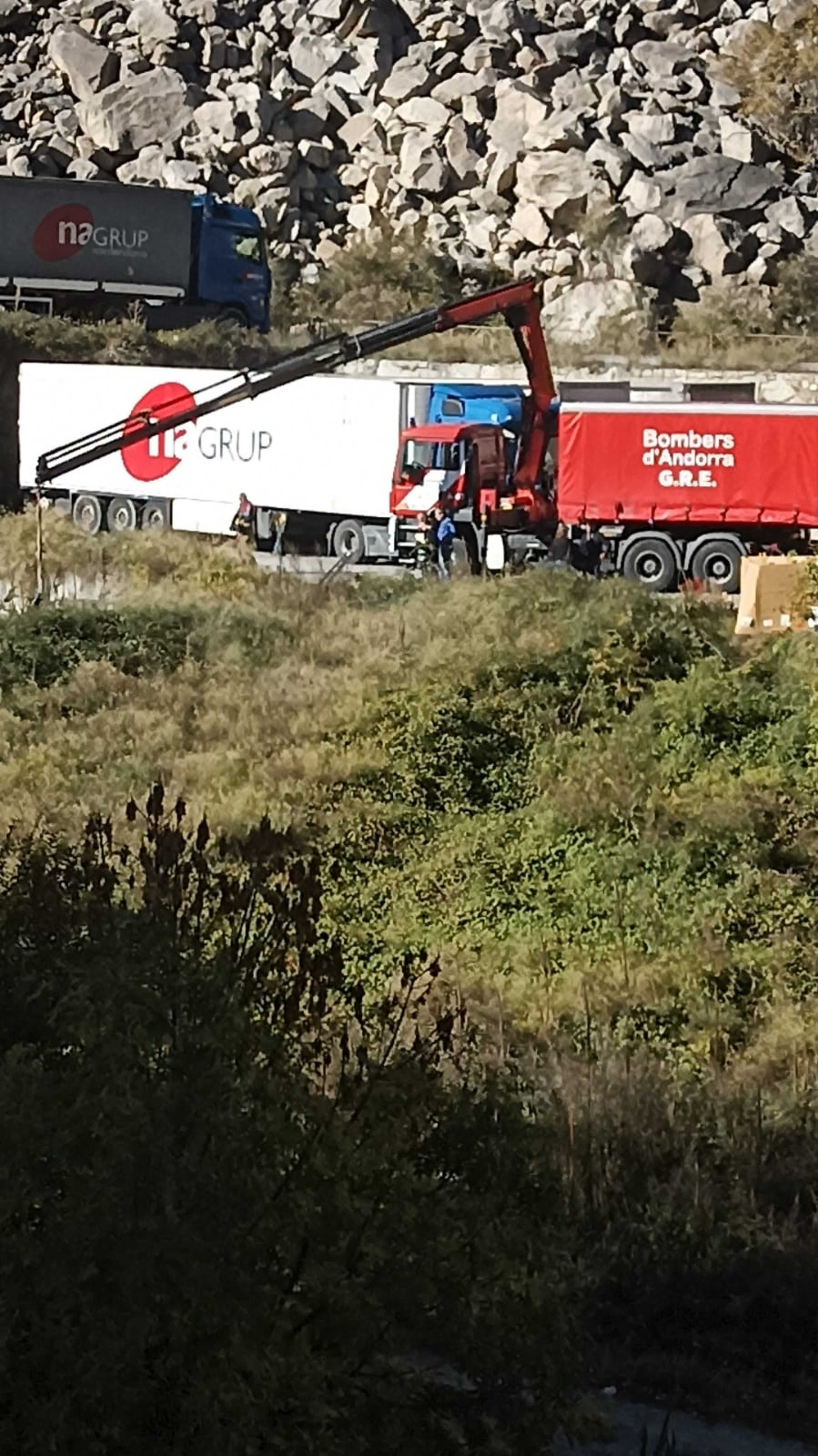 Un camió dels bombers amb grua treballant per recuperar el carretó bolcat. Un camió dels bombers amb grua treballant per recuperar el carretó bolcat.