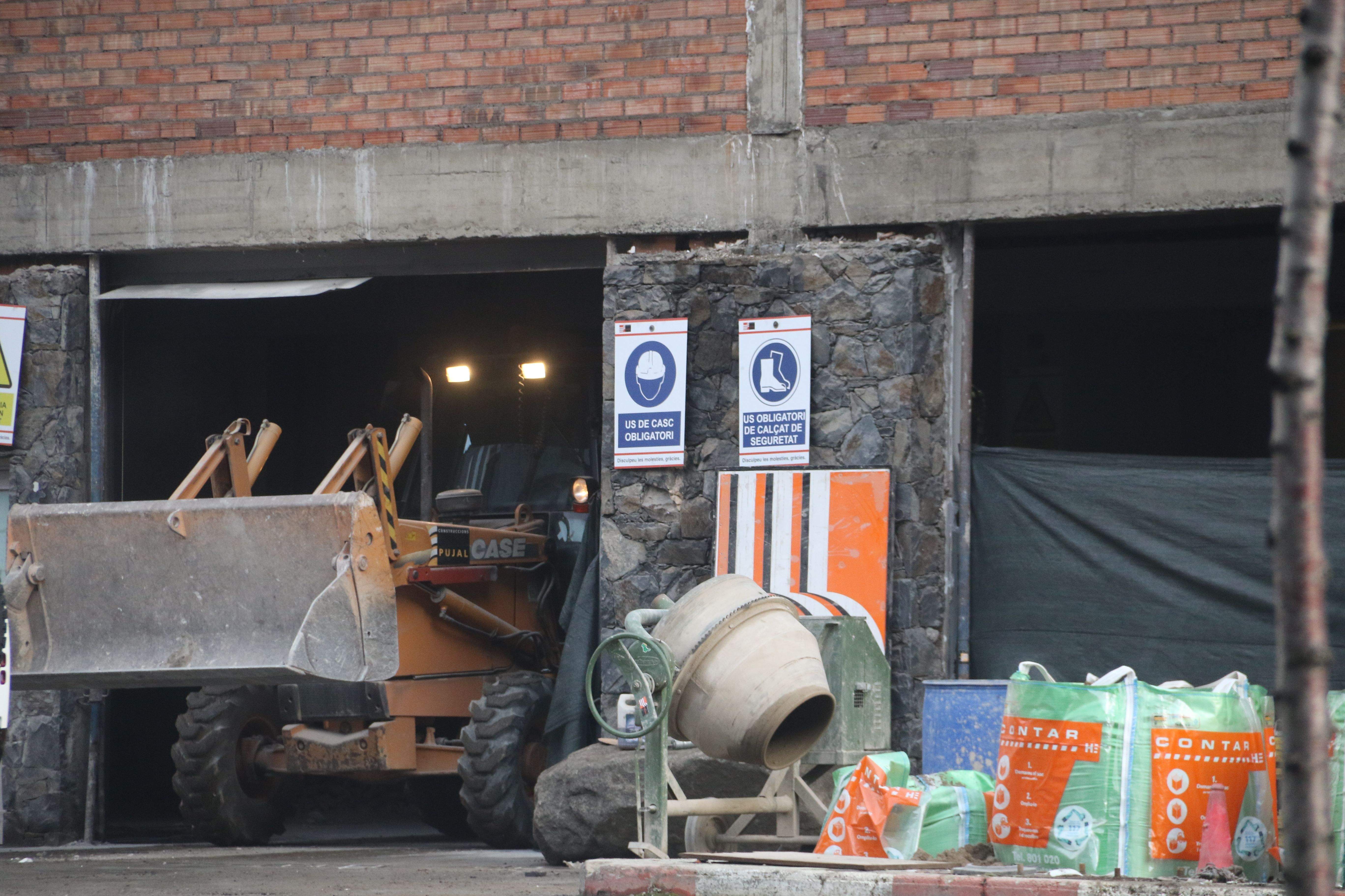 Una excavadora treballant en les naus, traient runa.
