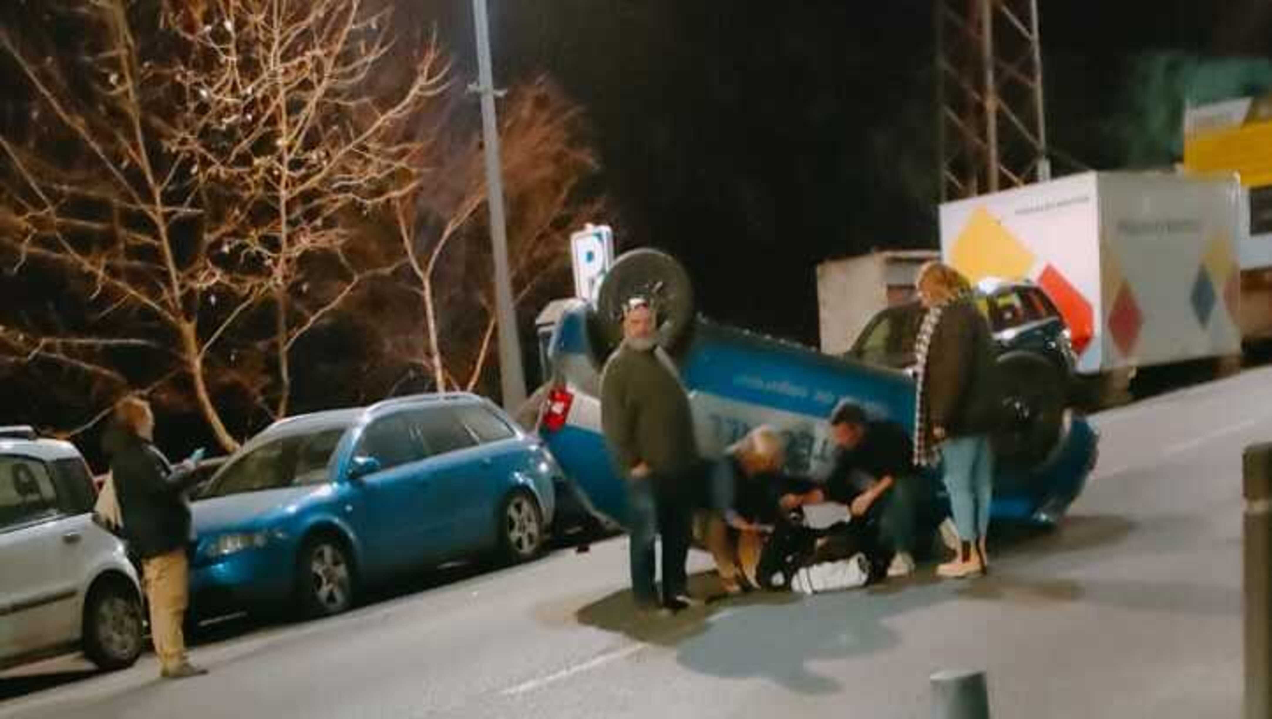 Veïns i usuaris de la via ajudant el conductor a sortir del vehicle.