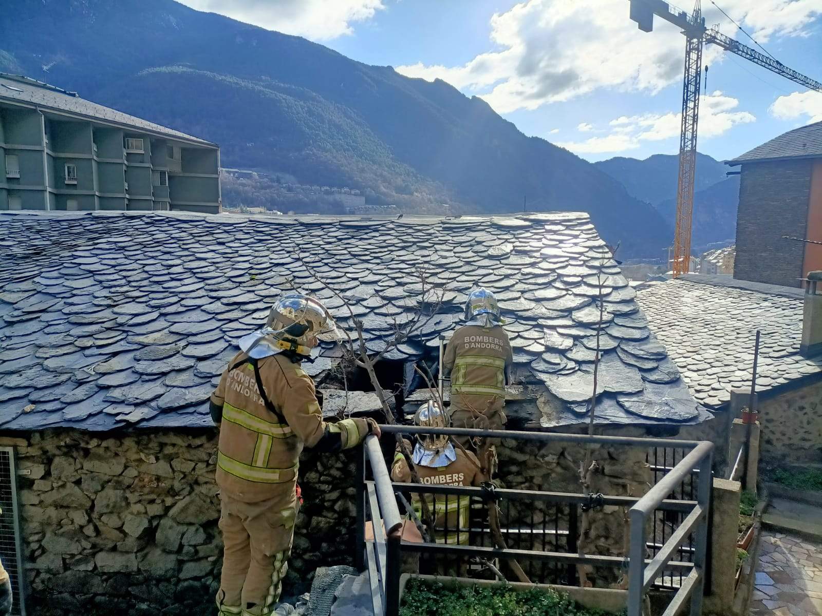 Bombers actuant en el llosat de l'edifici.