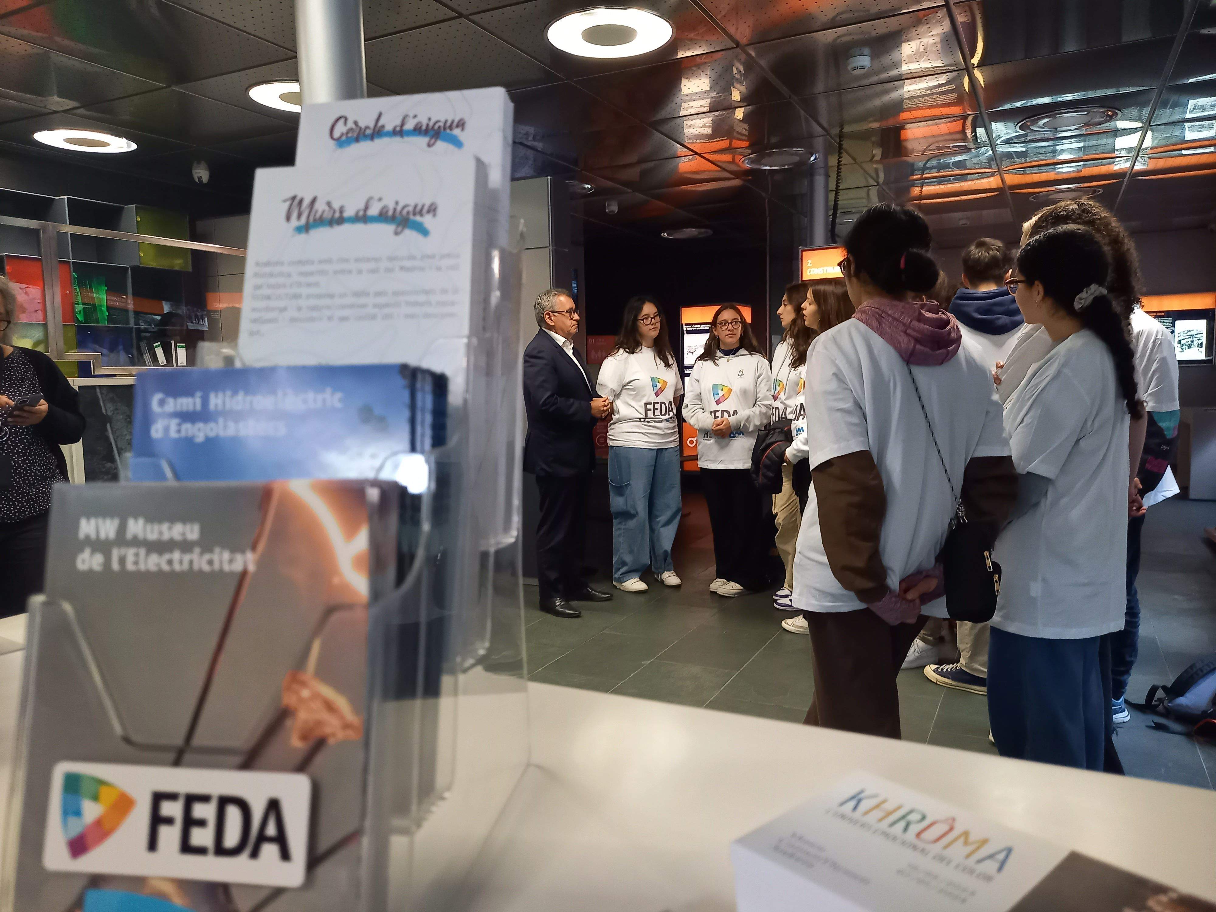 Albert Moles xerra amb alumnes del Lycée al vestíbul del Museu de l'Electricitat.