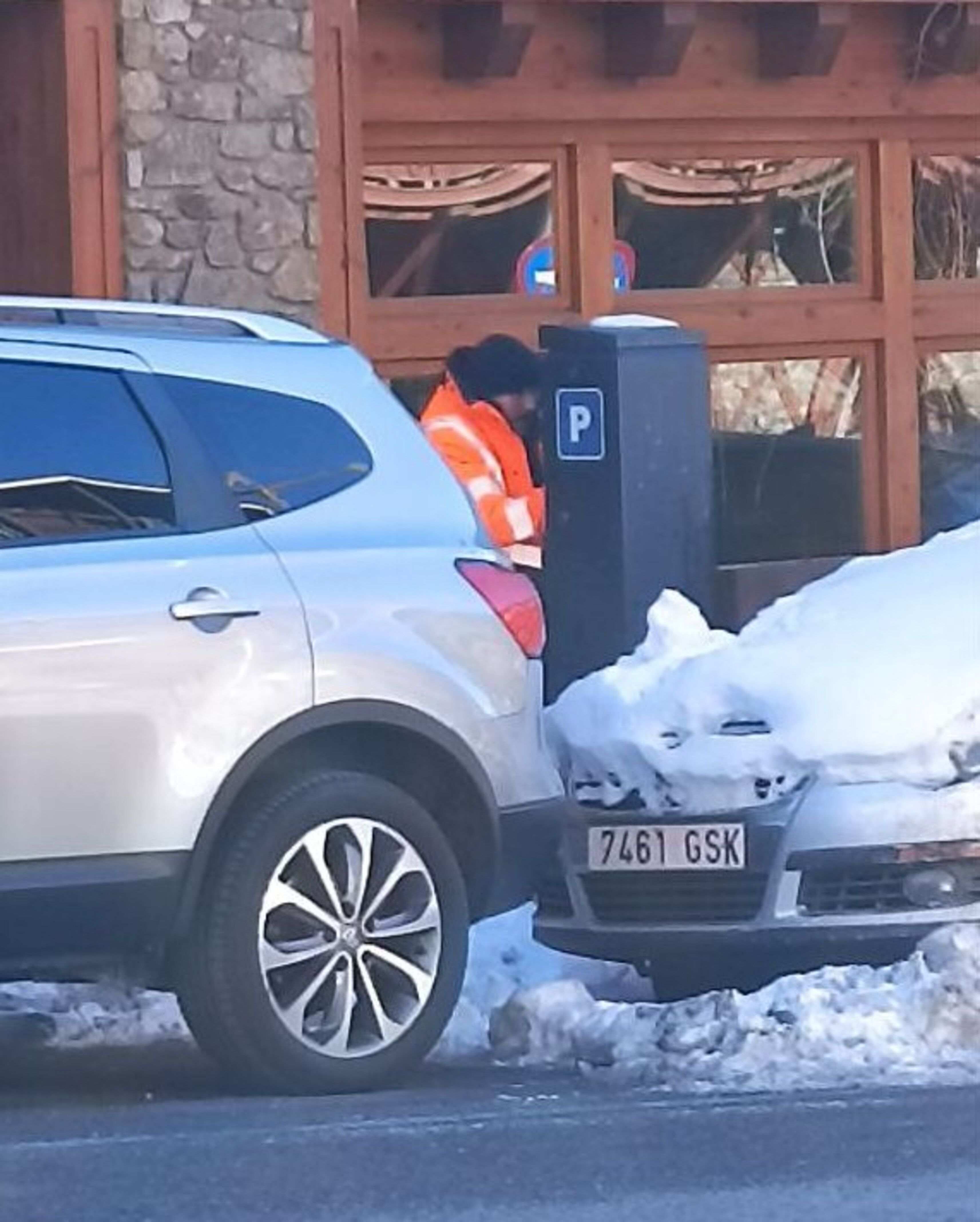 Un operari comprovant el funcionament d'un parquímetre de Soldeu.