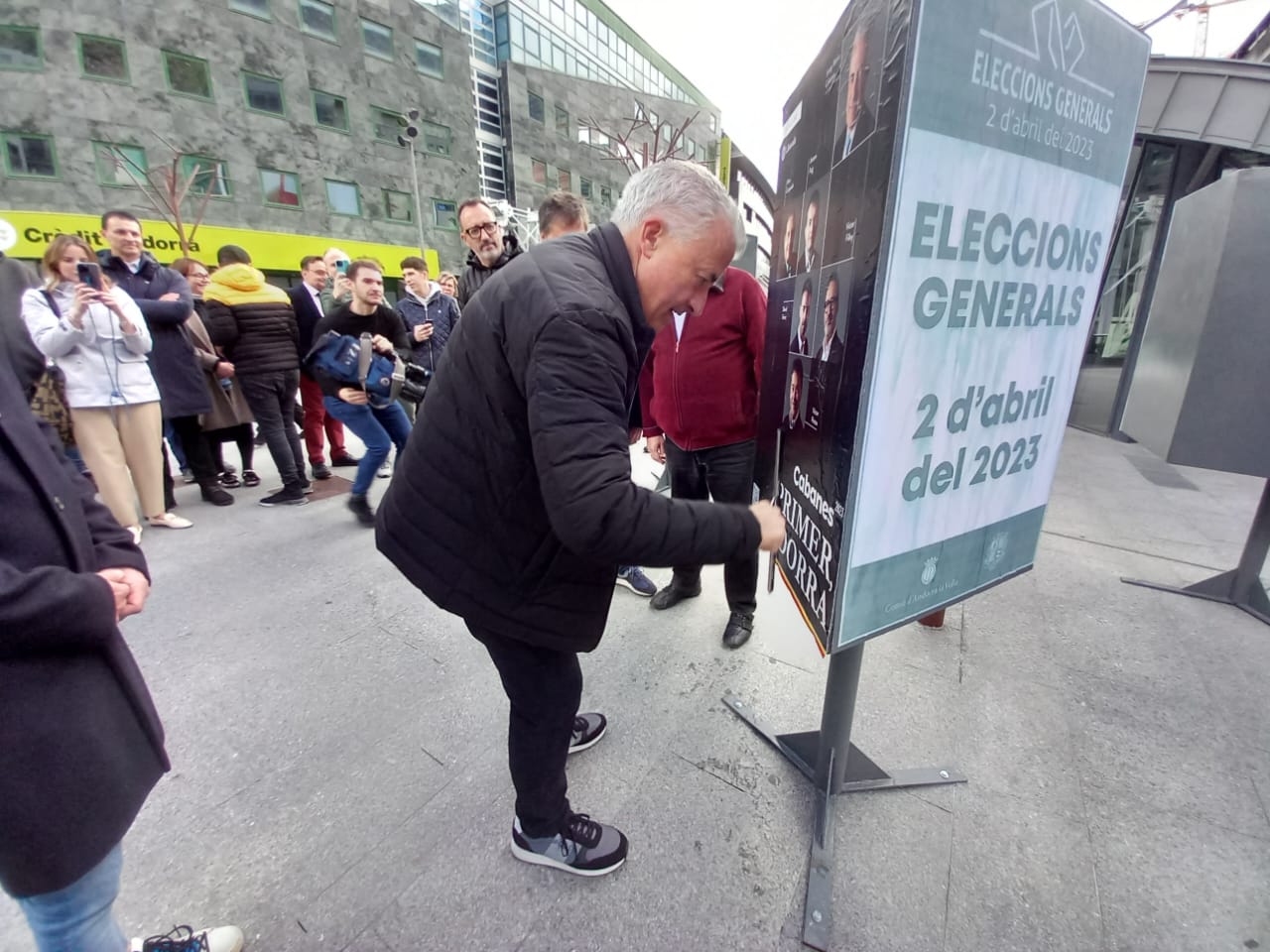 Josep Maria Cabanes enganxant el cartell sota l'atenta mirada de Gallardo i Filloy, entre altres.