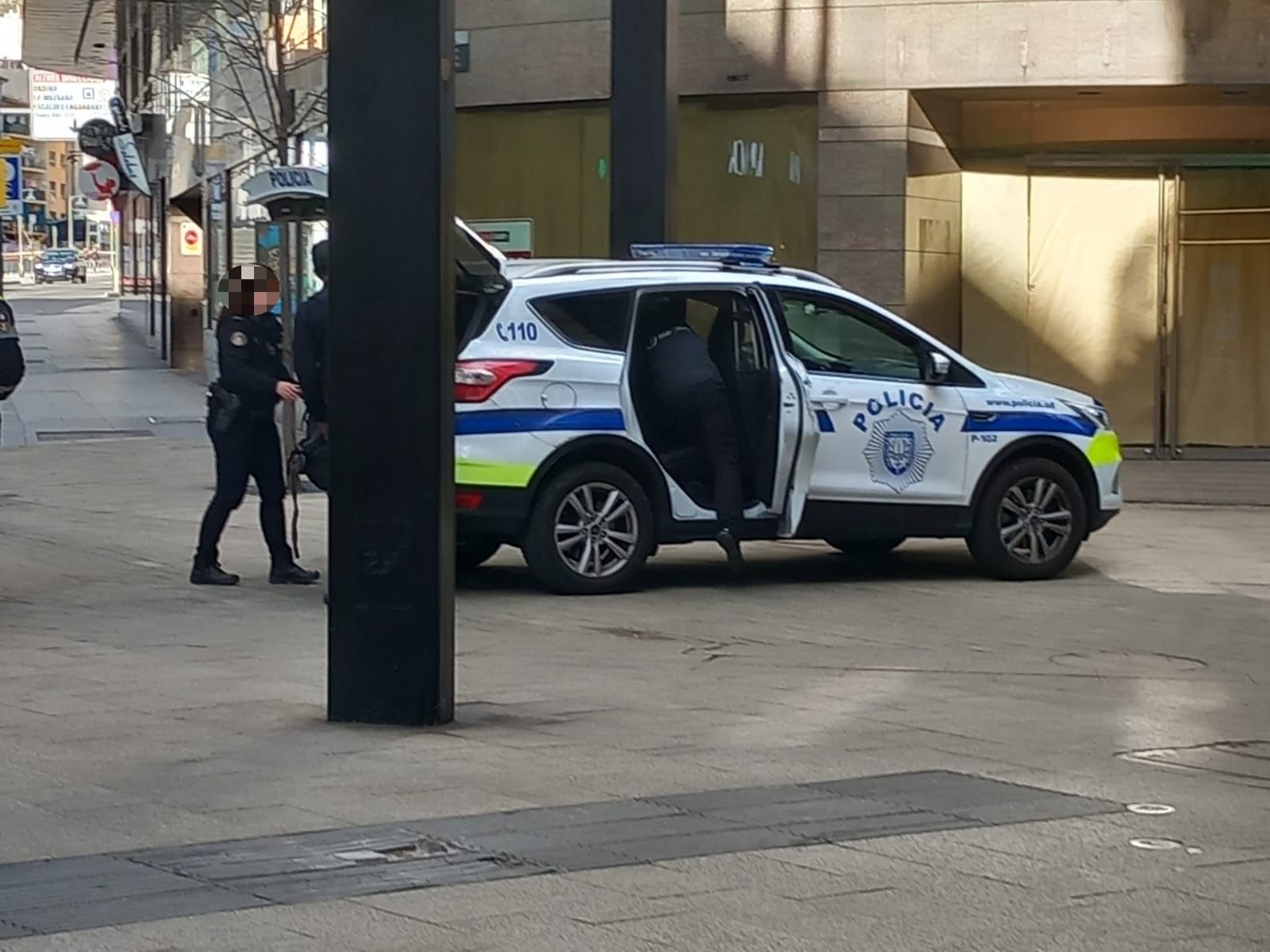 Moment en què els agents introdueixen l'home i les seves pertinences al cotxe policial.