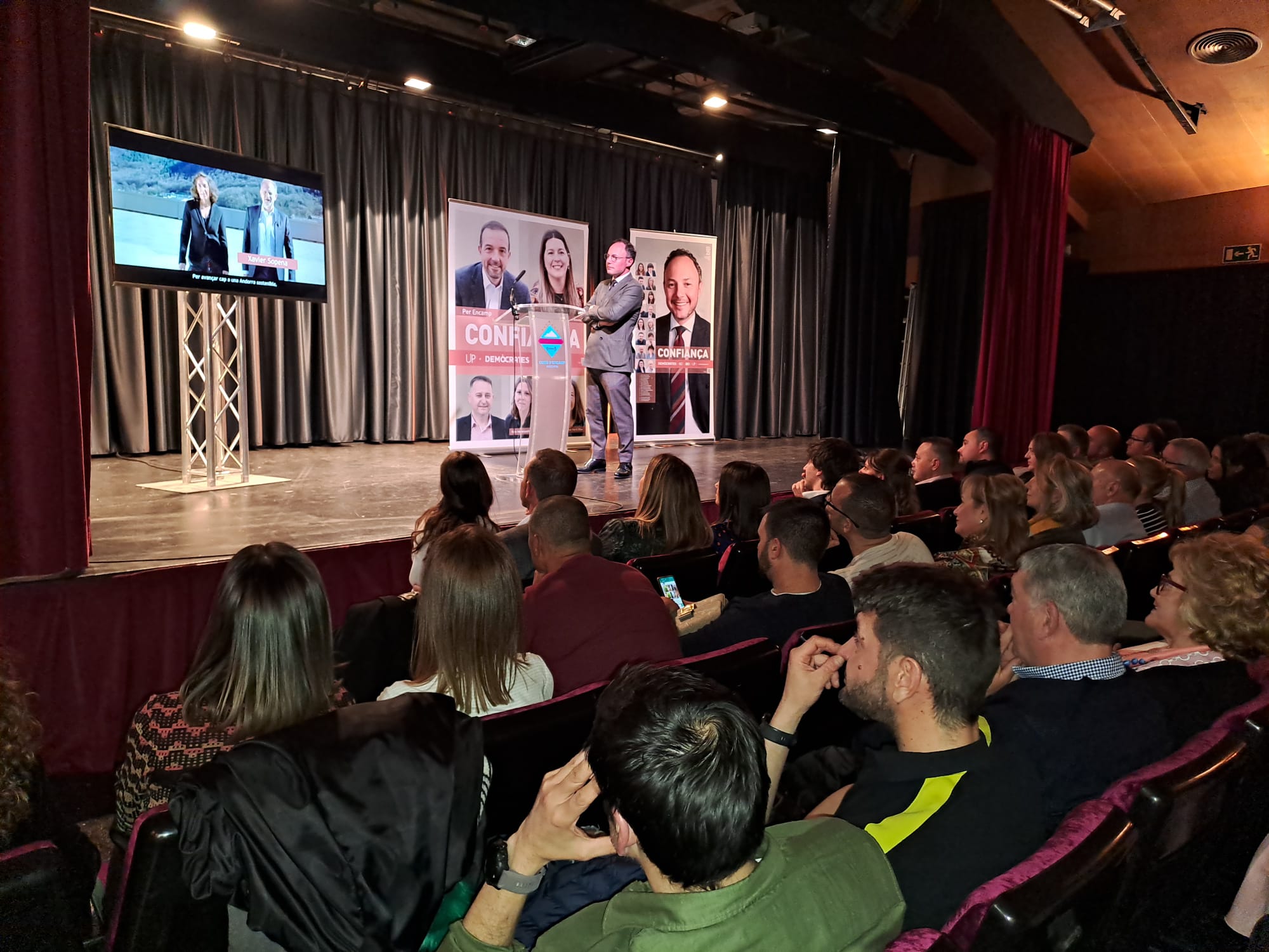 Espot es mira l'anunci electoral de la formació a sobre l'escenari.