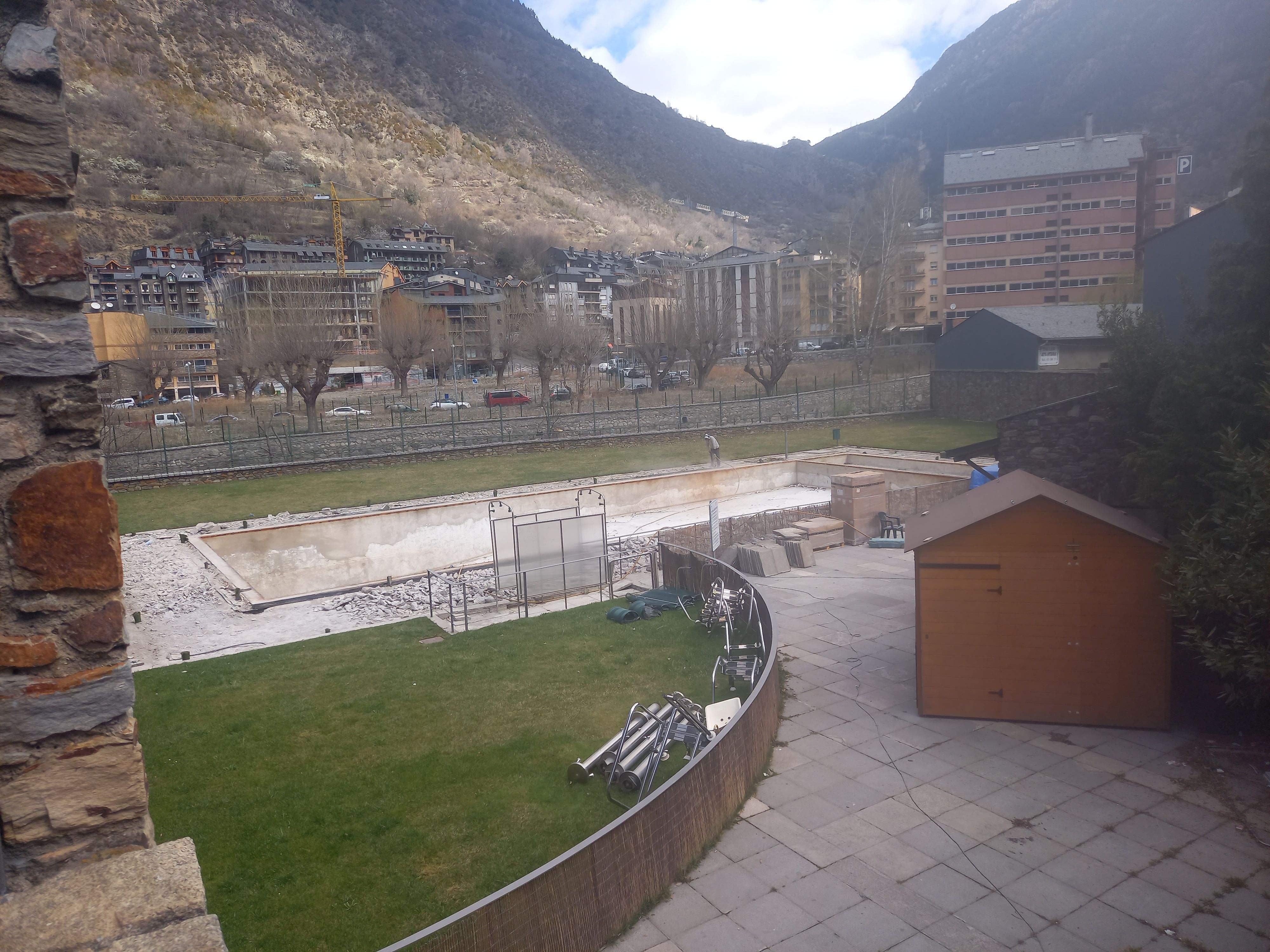 Un operari treballa a les obres de la piscina.