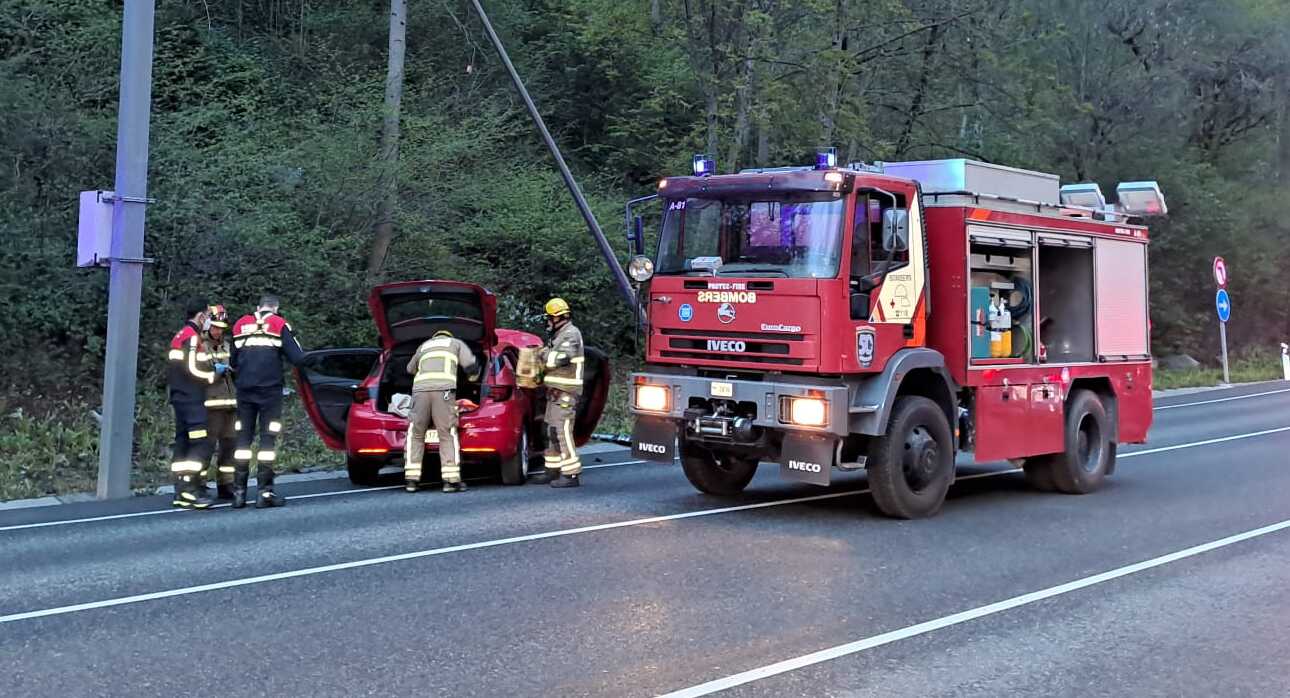 Els bombers treballant en el lloc dels fets a redós del vehicle.