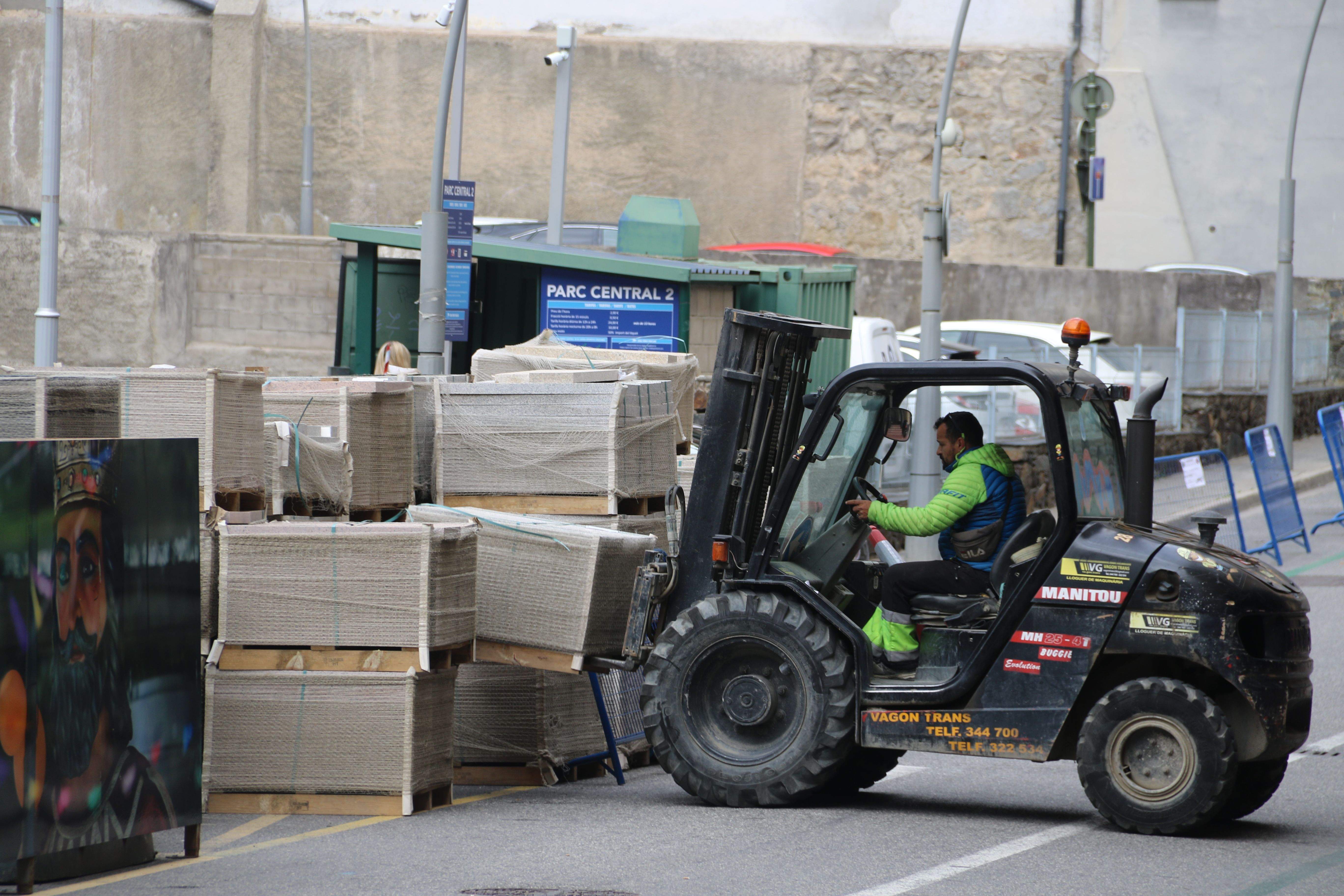 Un operari dipositant els palets al carrer Pompeu Fabra.