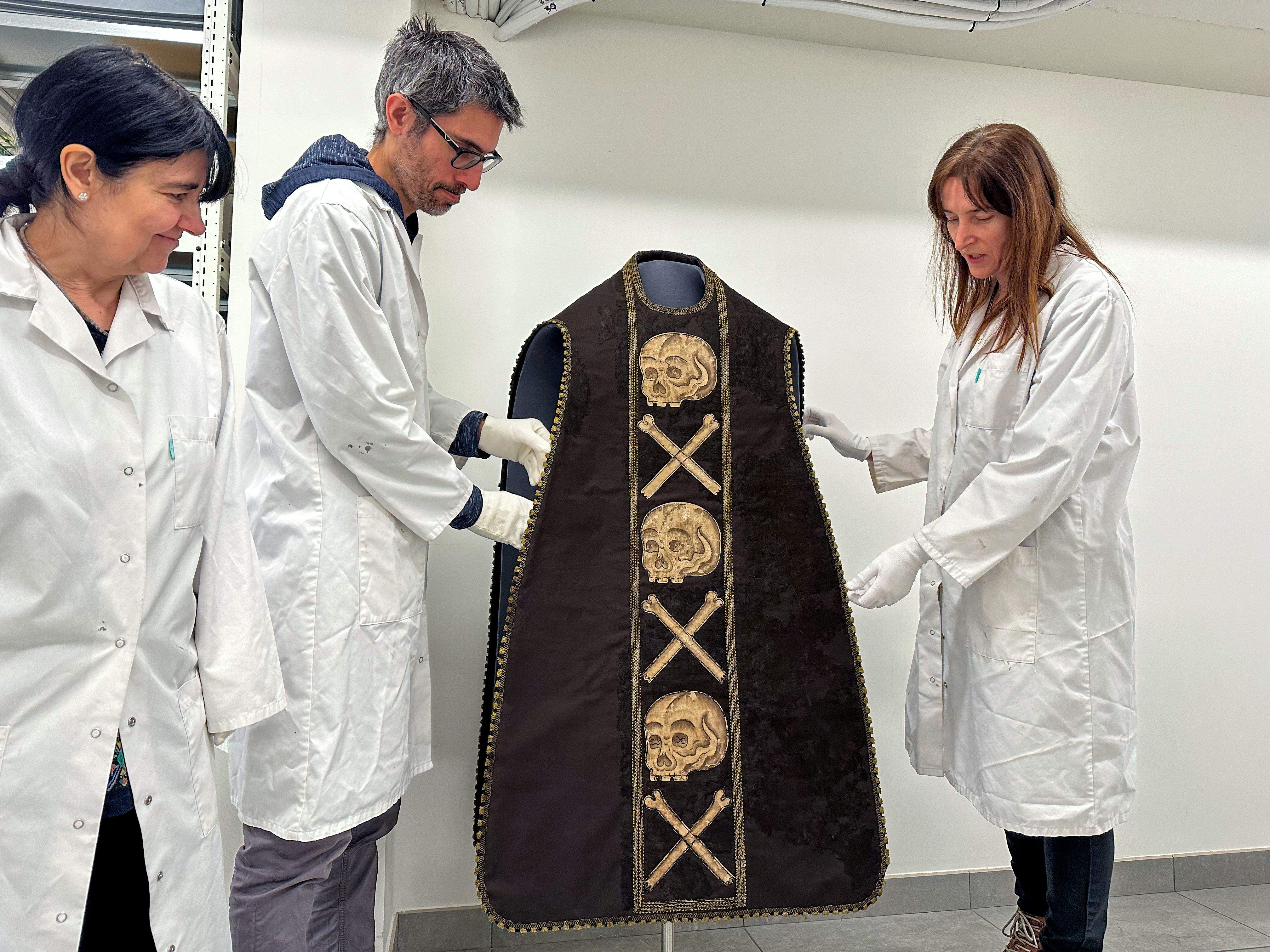 Alguns dels restauradors mostrant la casulla.