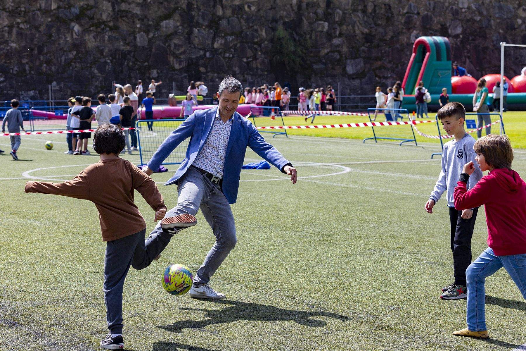 El cònsol jugant al futbol amb alguns nens.