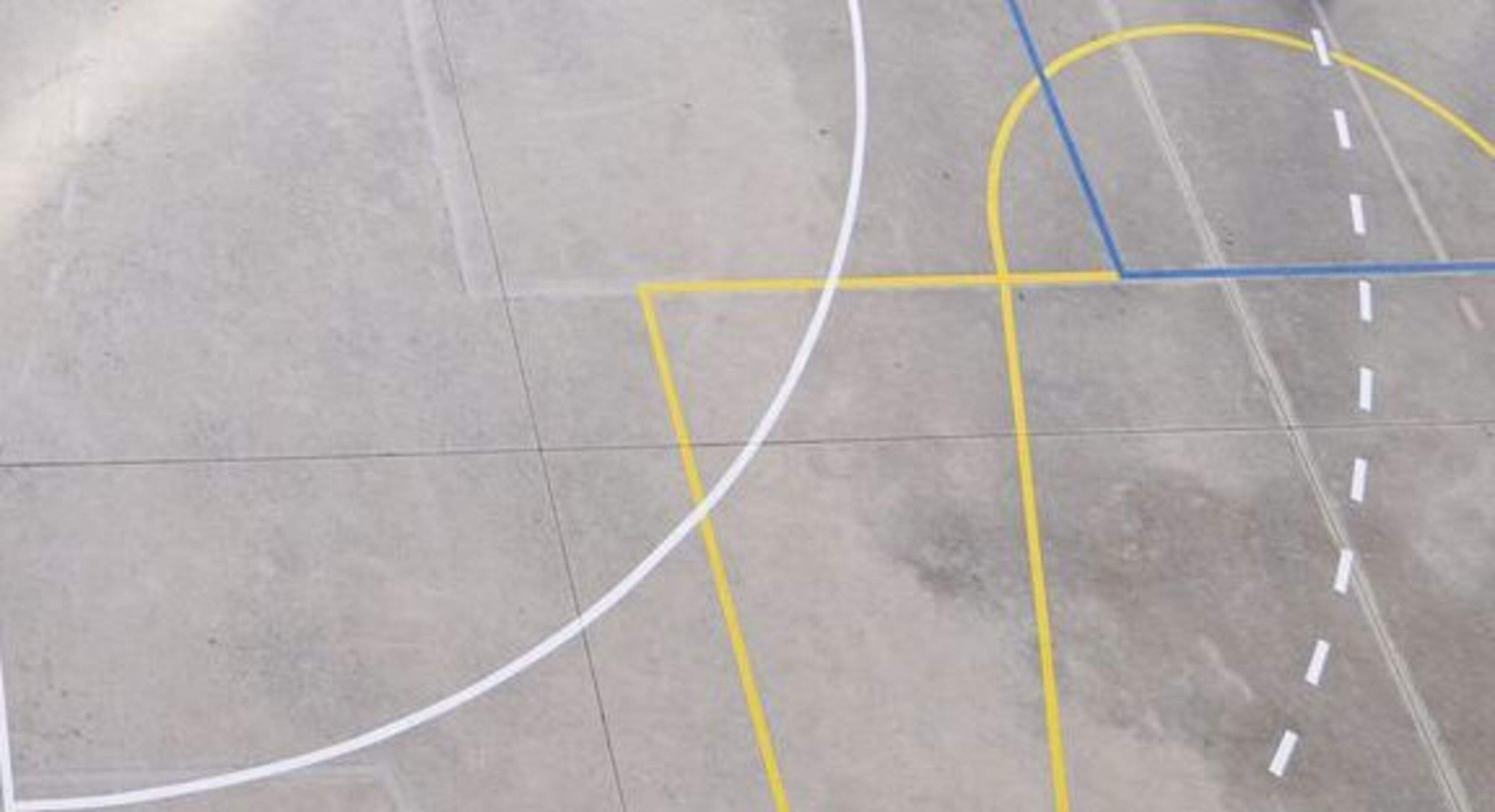 Línies de senyalització de terrenys de joc de diversos esports en el pati d'una escola.