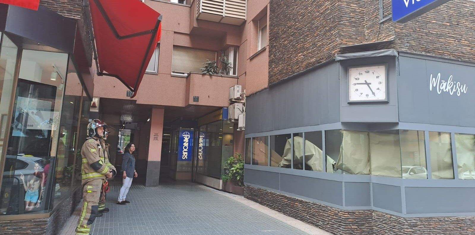 Dos bombers a l'exterior de la botiga on hi ha hagut l'ensurt.