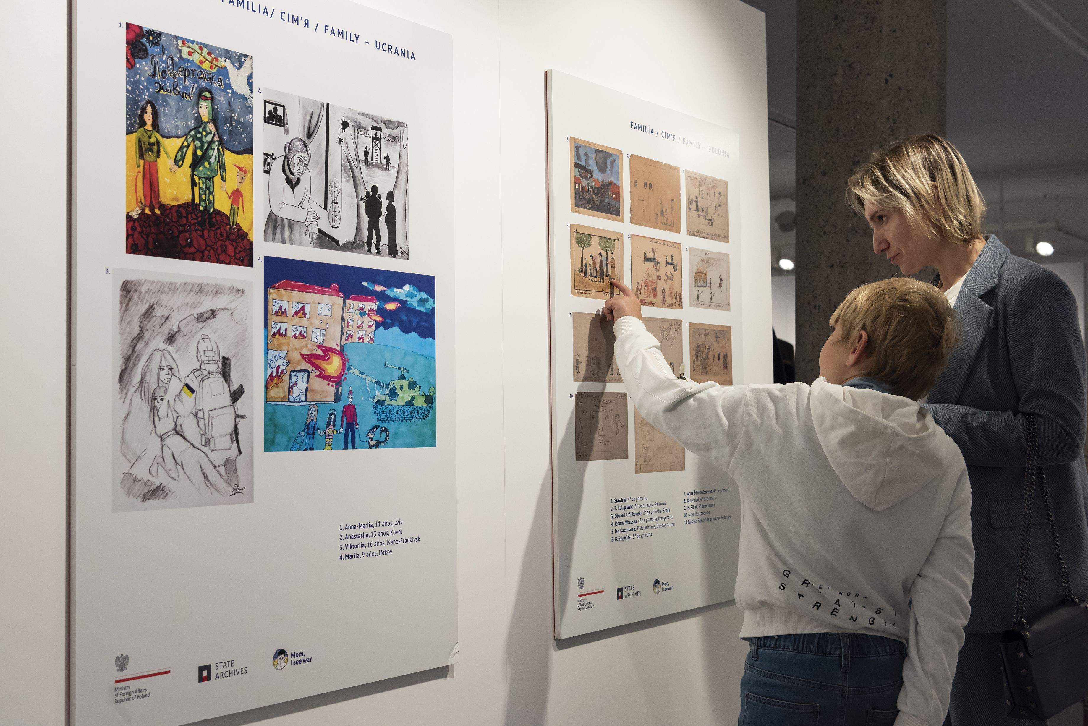 Una mare i un fill mirant detalls de l'exposició.