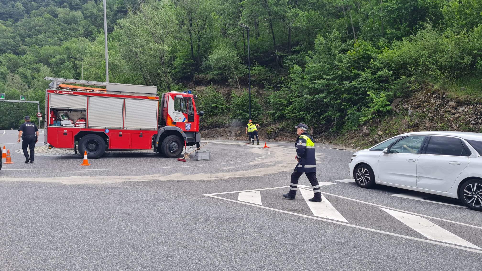 Efectius dels bombers netejant la carretera.