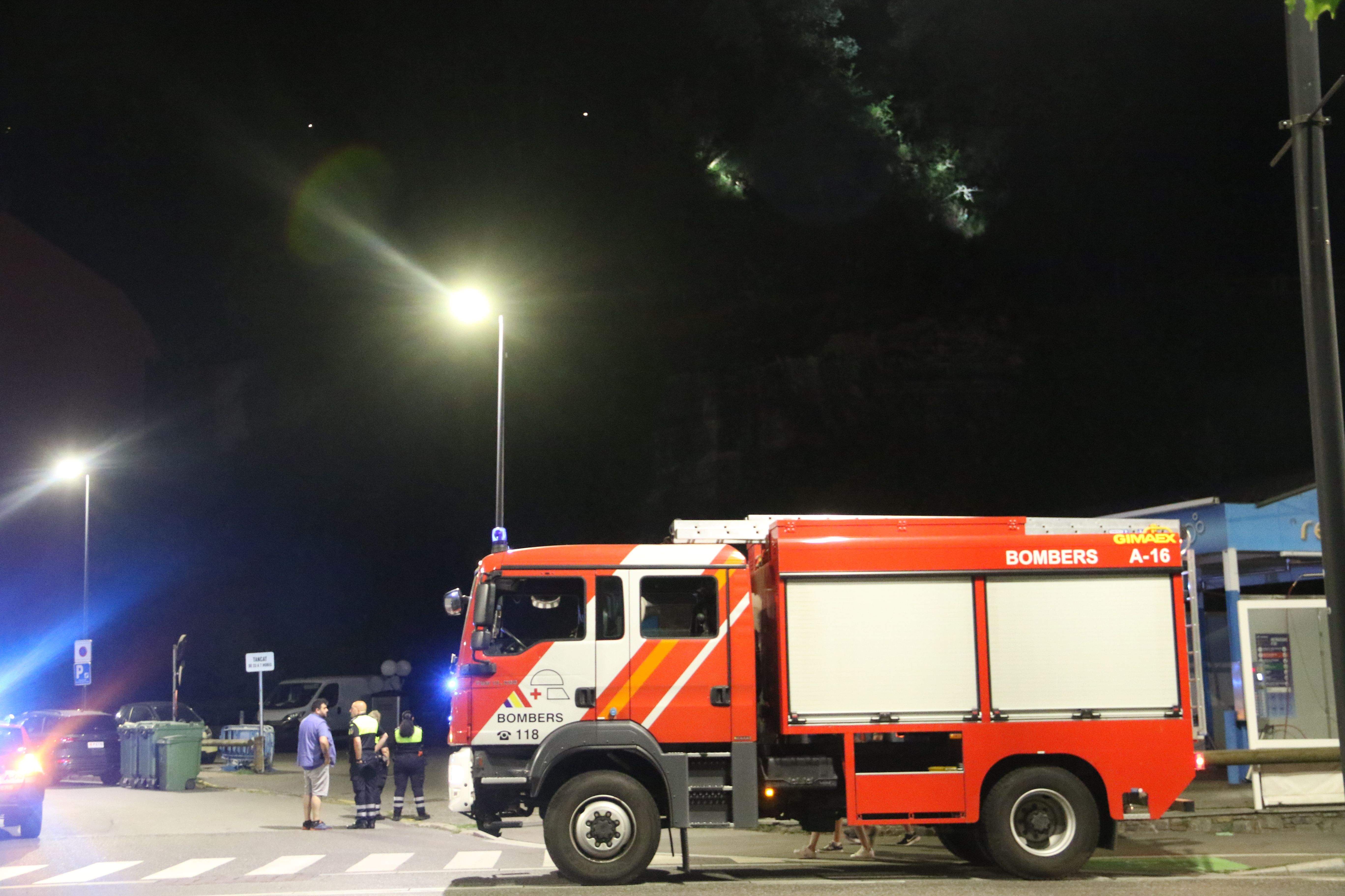 Dos bombers cercant l'origen del foc amb un camió estacionat a l'avinguda Tarragona.