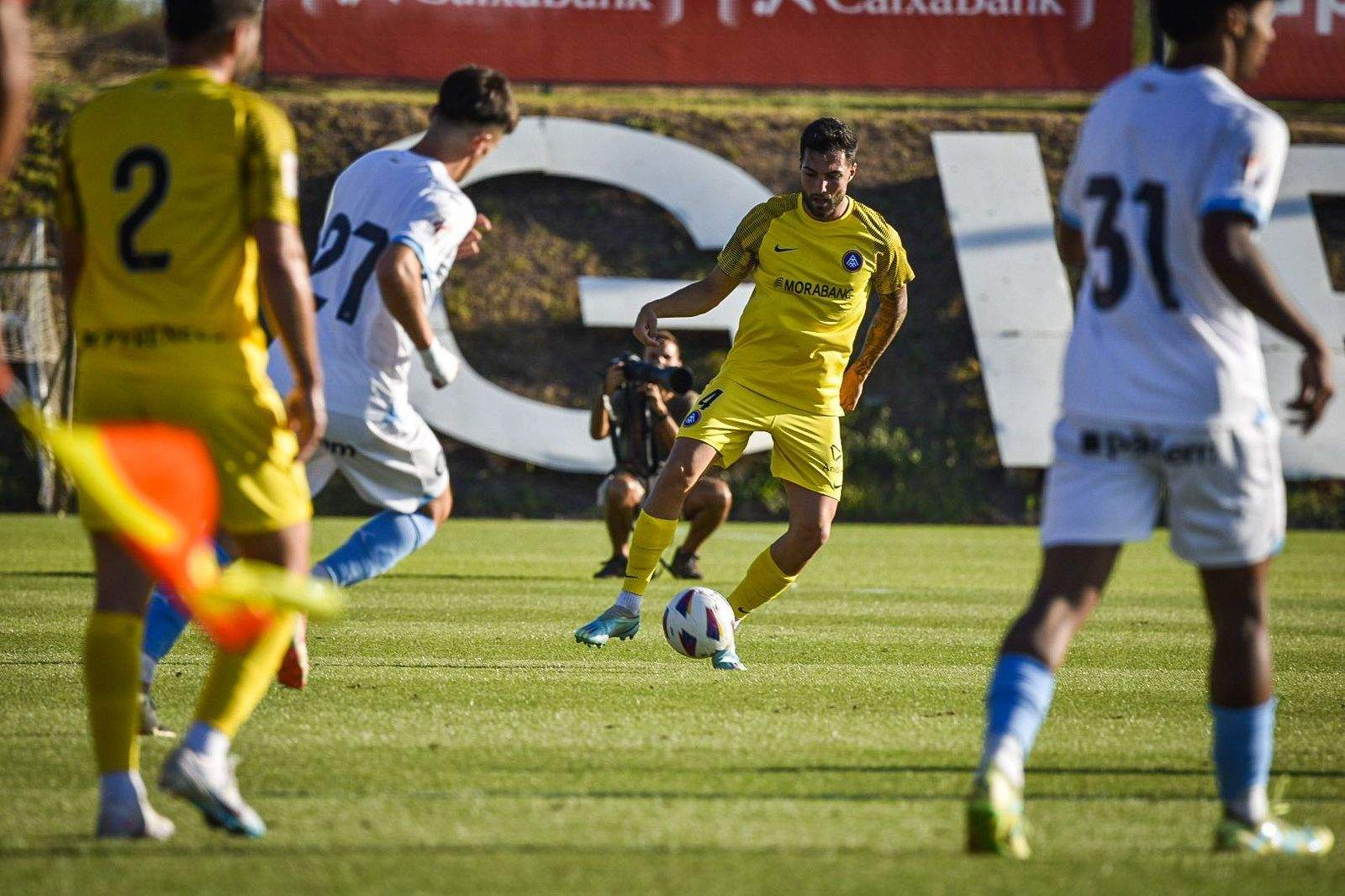 Álex Pastor controla una pilota entre Pau Víctor i Jastin i en presència de Migue Leal al partit d'aquest dissabte a la Vinya.