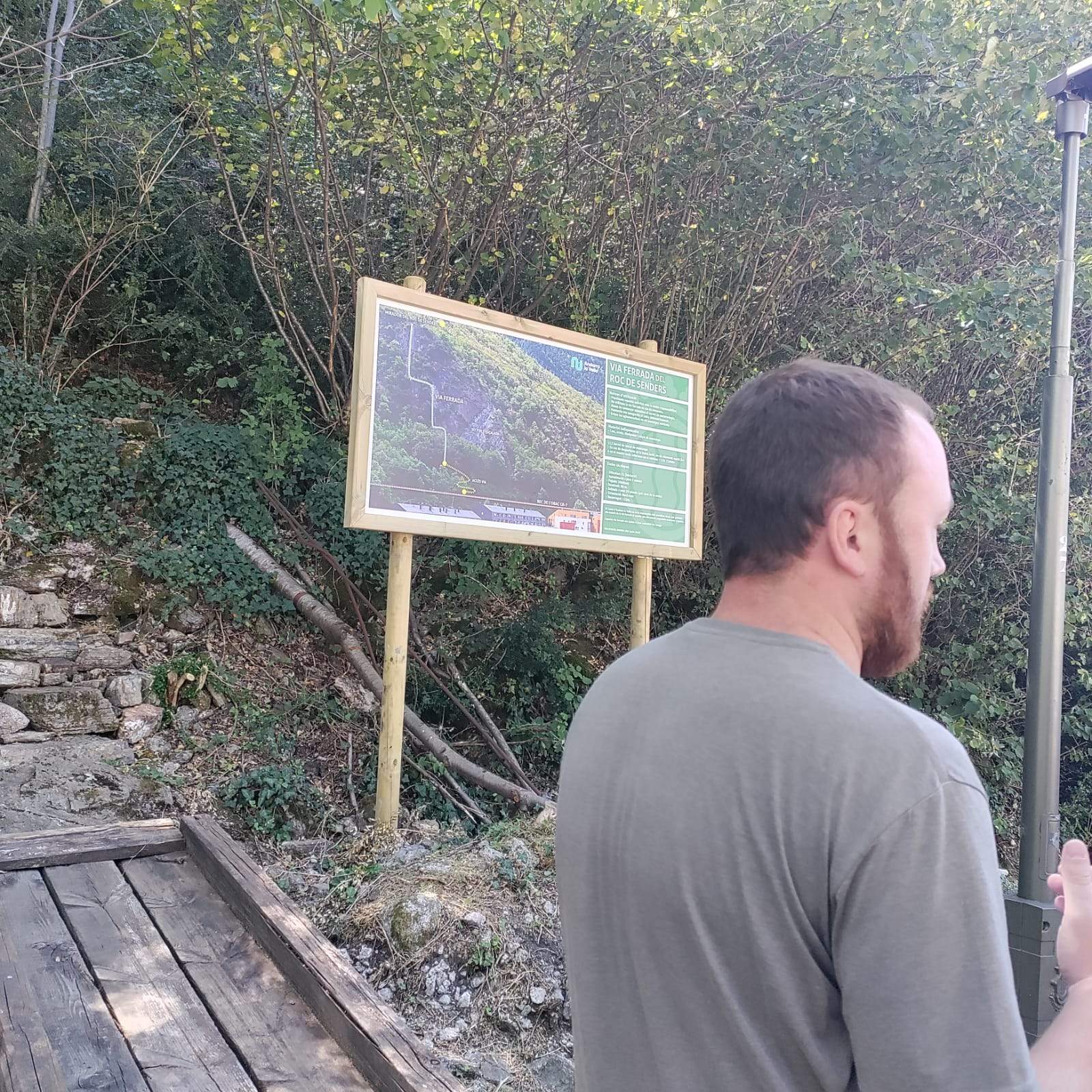 El conseller de Patrmoni Natural, Gerard Menardia amb el cartell de la via ferrada al fons.